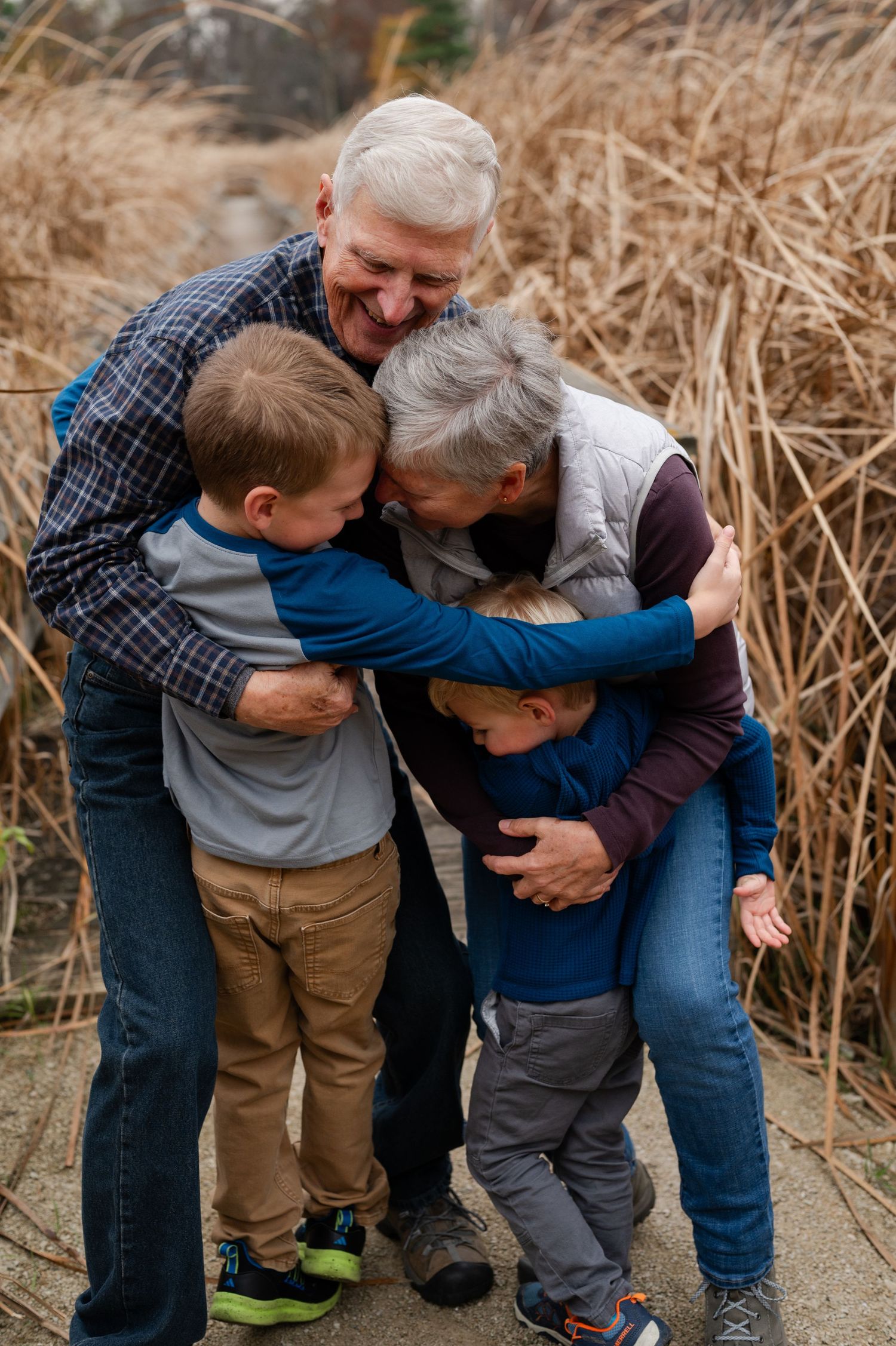 Family sharing warm embrace and laughing together on nature trail.