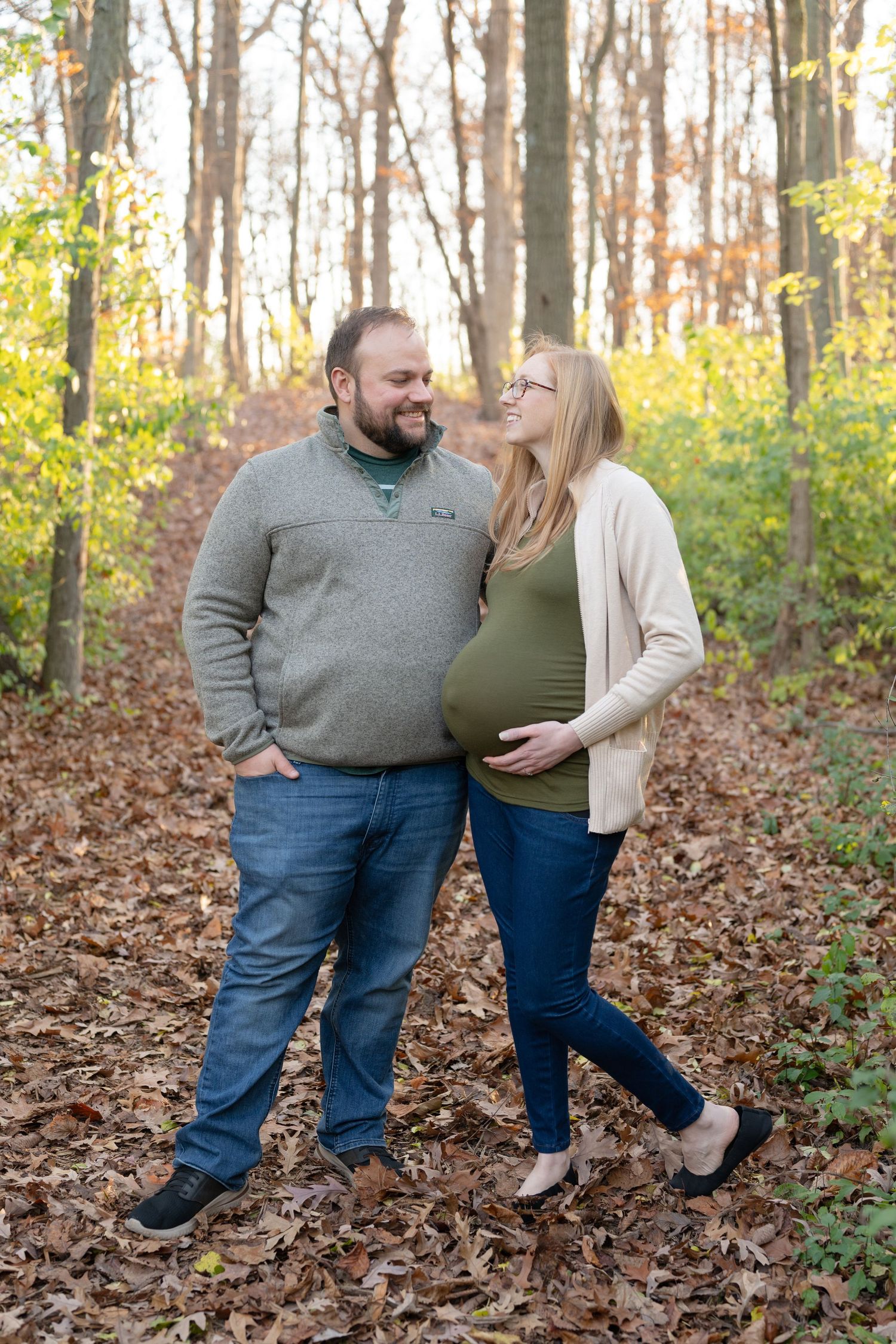 Couple sharing intimate moment while standing in autumn forest.
