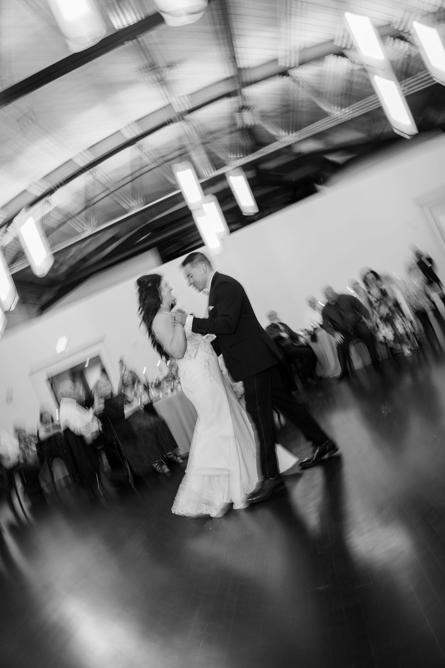 Black and white photo of bride and groom sharing their first dance at wedding reception.