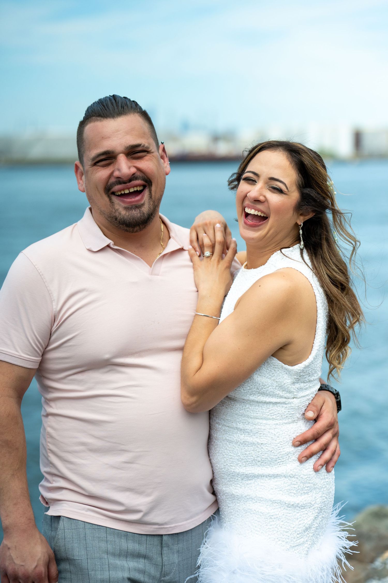 Couple smiling together on beach during engagement session