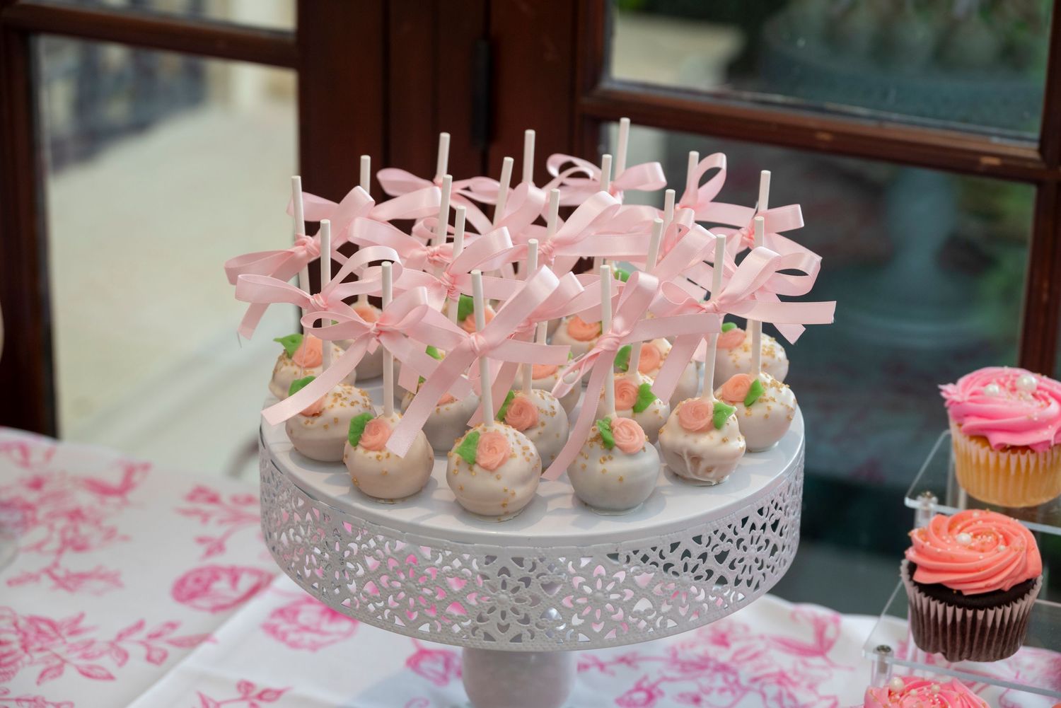 Pink cake pops displayed on dessert stand