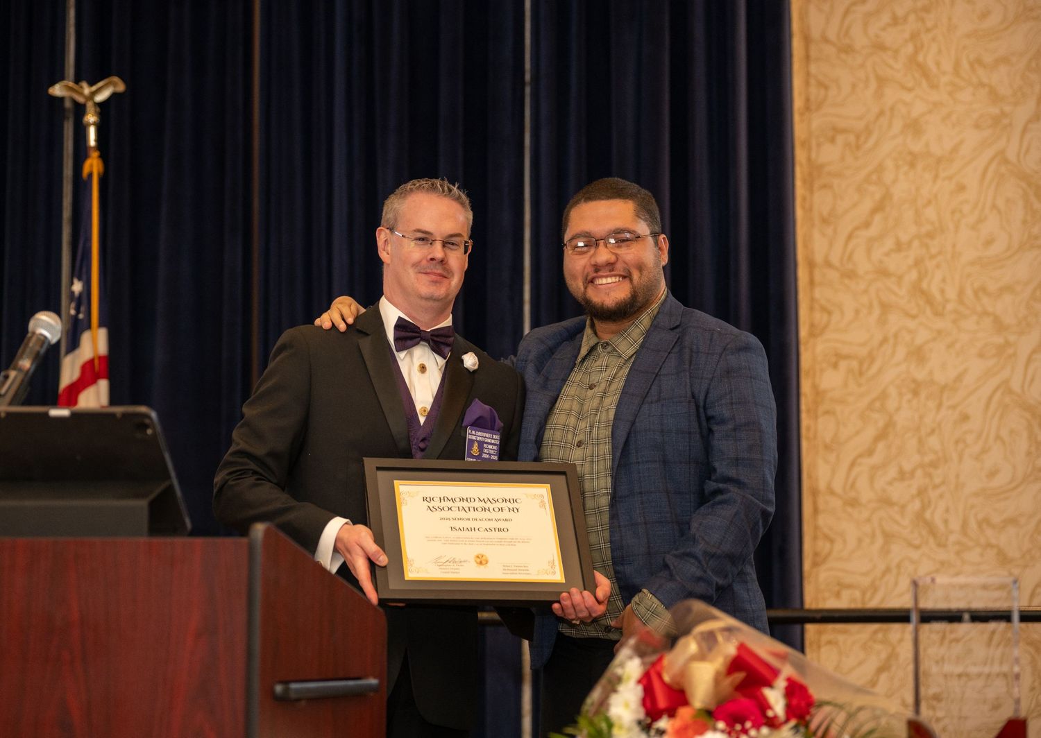Two men speaking on stage during corporate ceremony