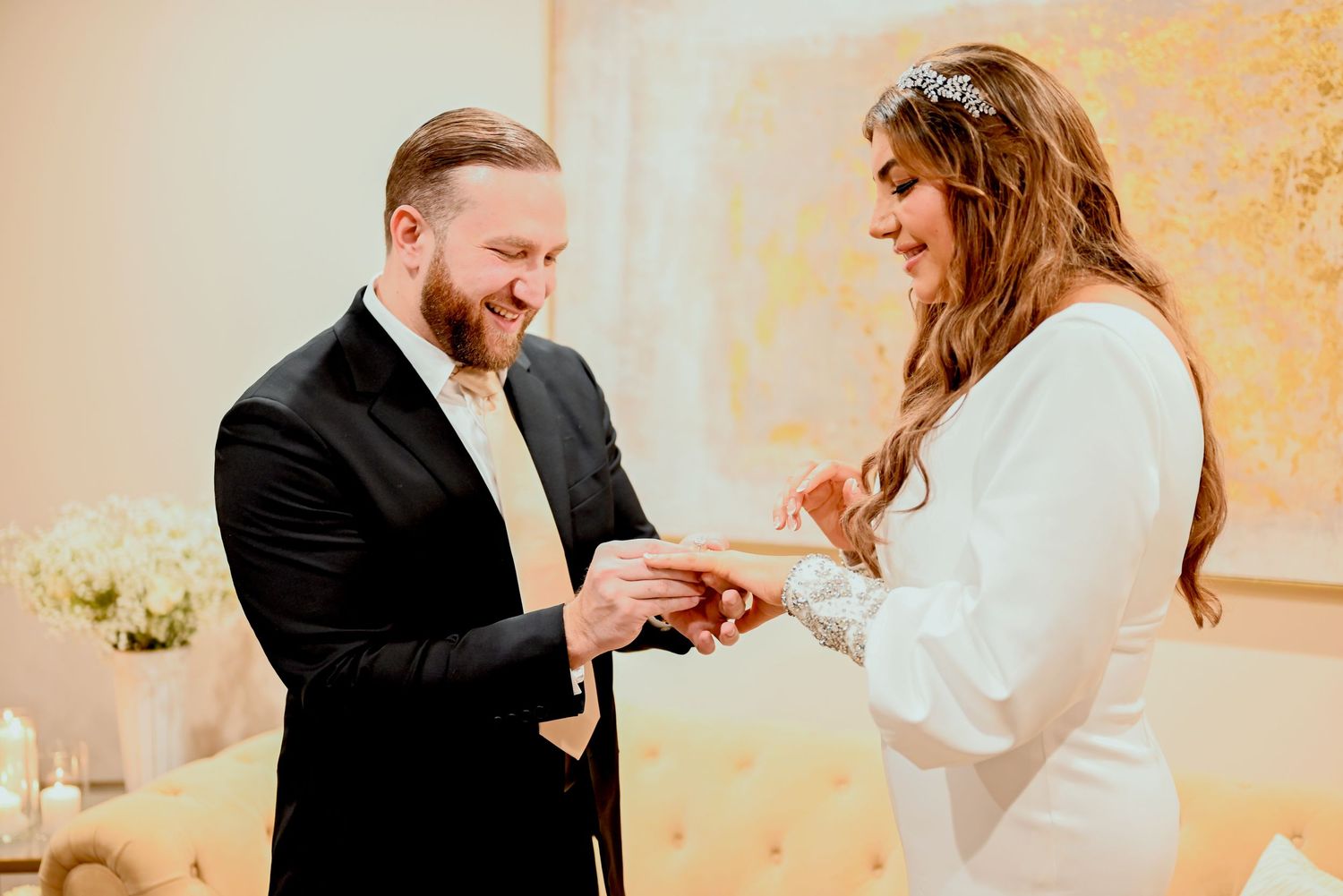 Groom placing wedding ring on bride’s finger during ceremony