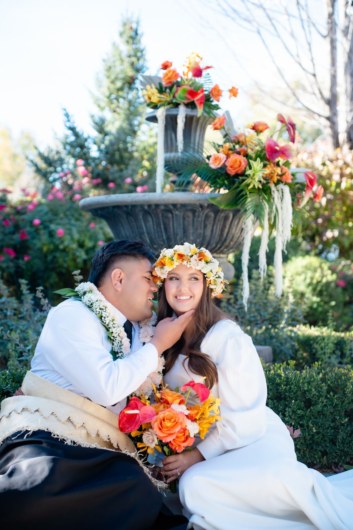 Romantic garden wedding scene with floral crowns and white attire.