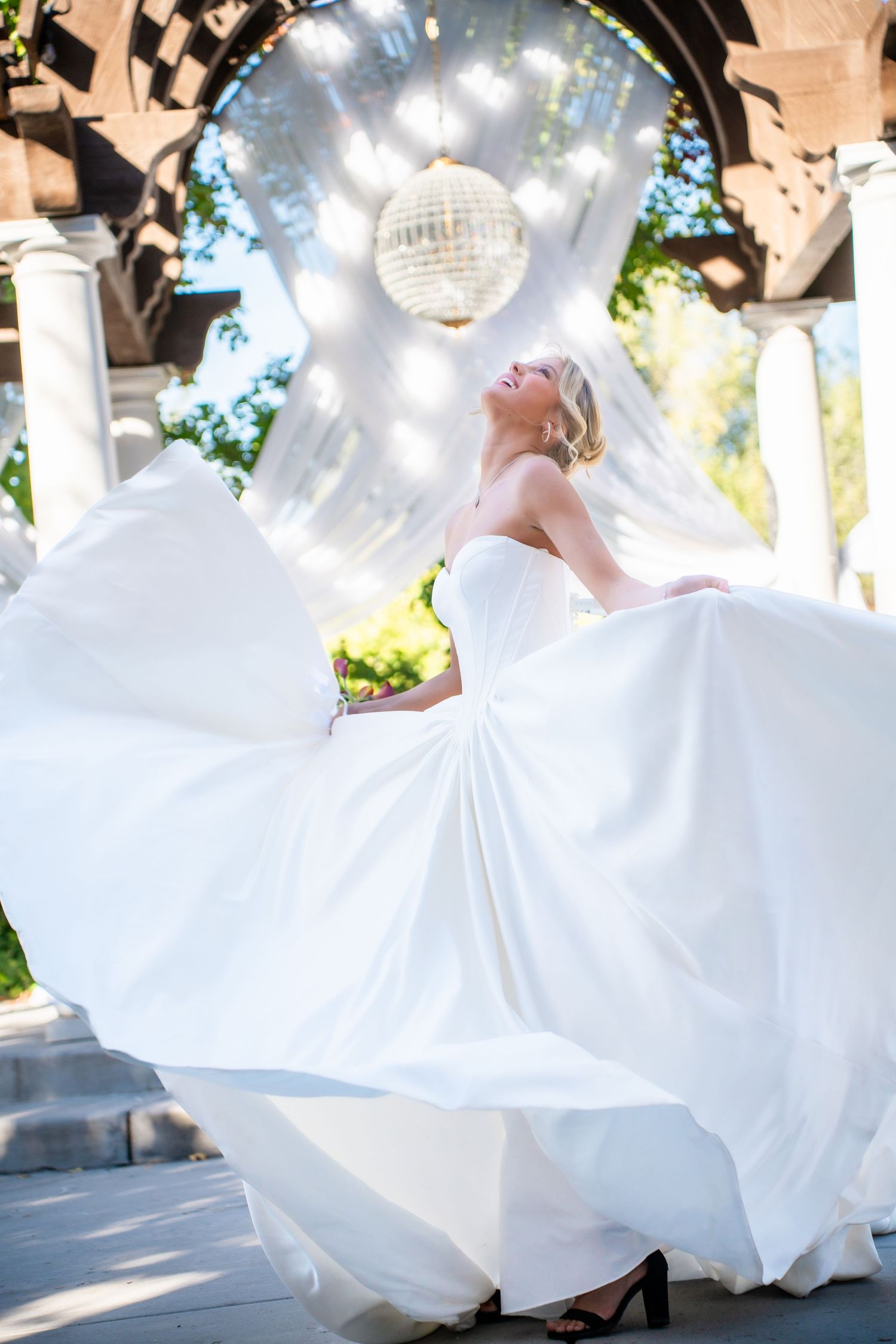 Flowing white wedding dress twirling under sparkling disco balls and string lights.