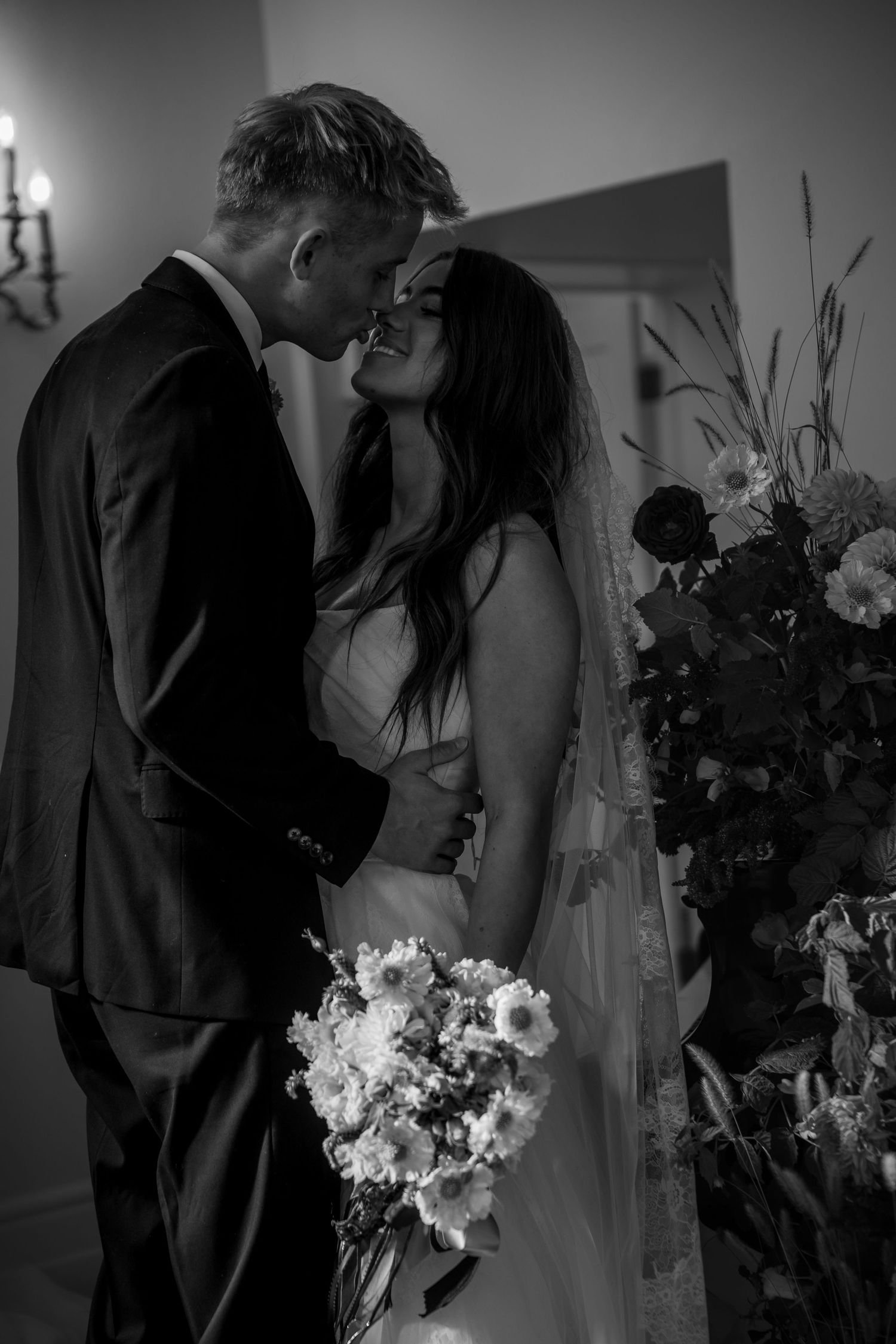 Black and white wedding photo series showing romantic moments between newlyweds.
