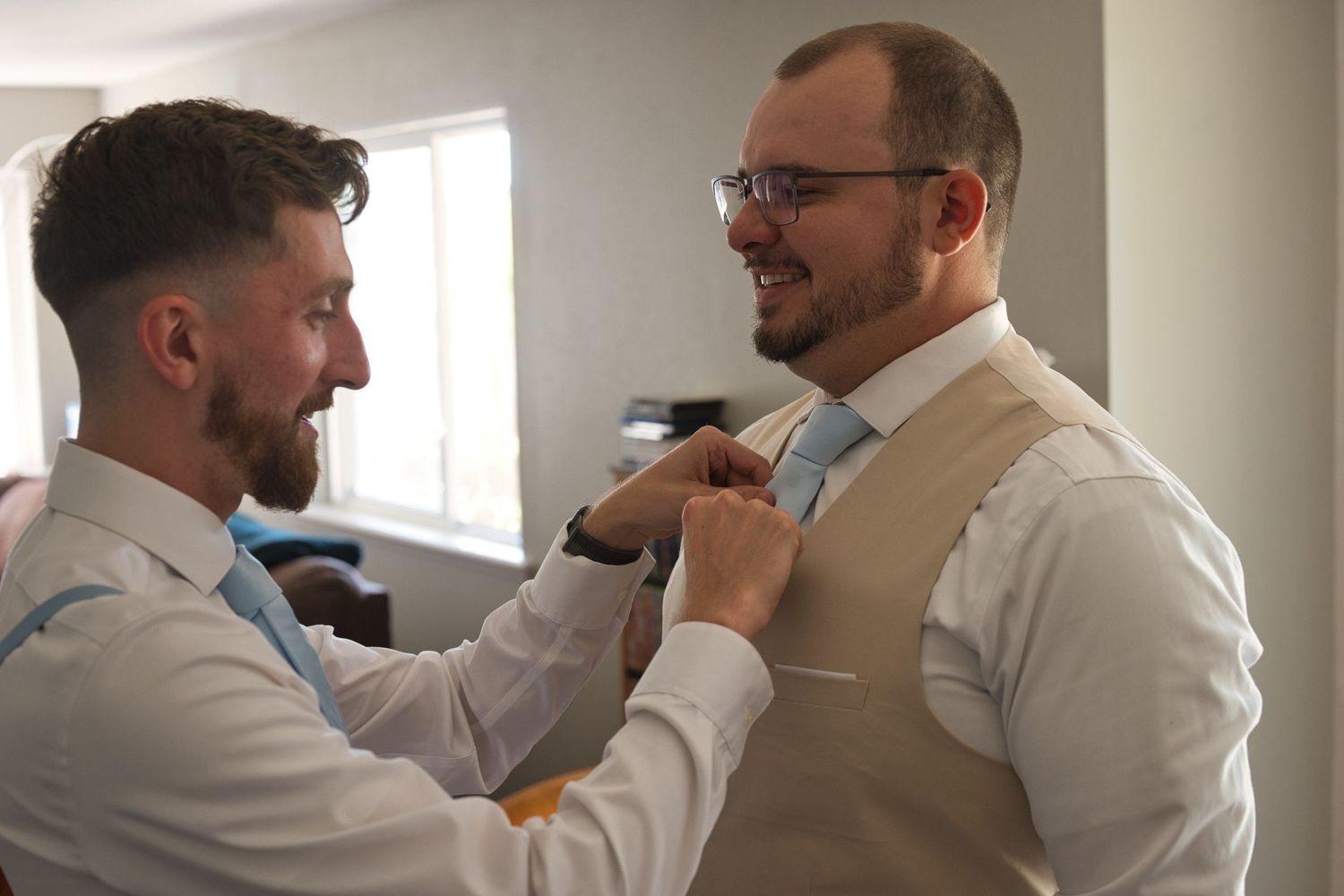 Groom getting ready while friend fixes his tie in Moscow, Idaho