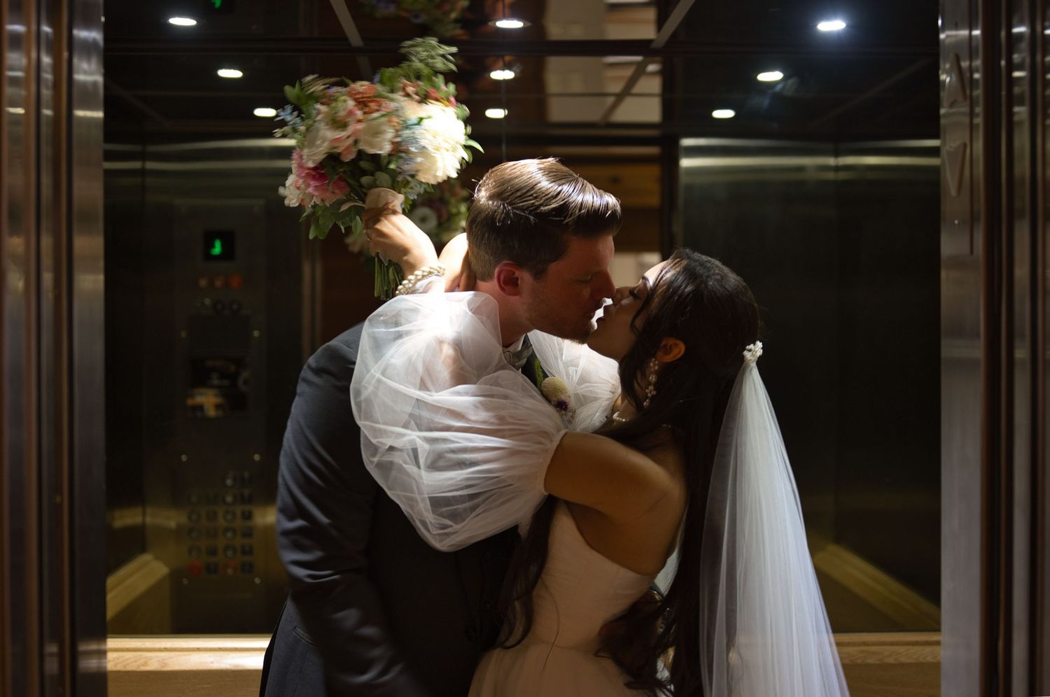 Bride and groom share kiss in elevator
