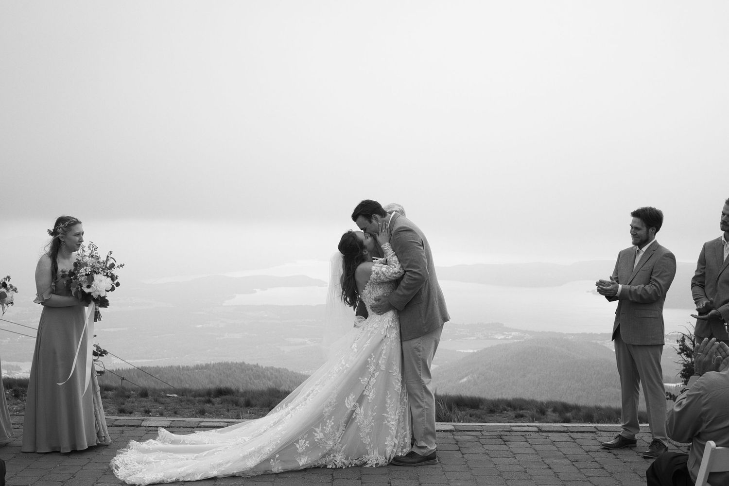 Elegant couple kissing during wedding ceremony on mountaintop