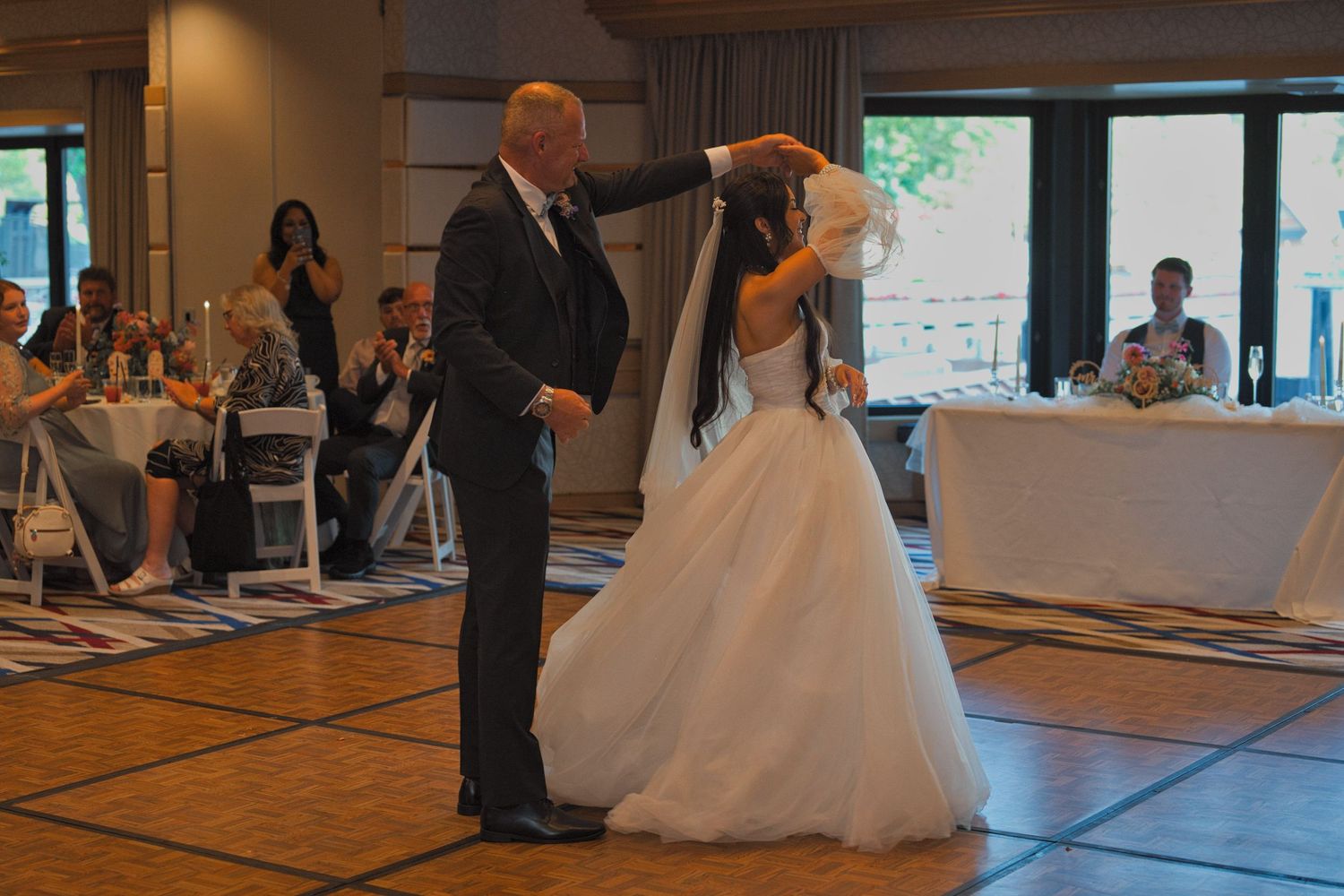 Bride's father twirls the bride as they dance during the father-daughter dance.