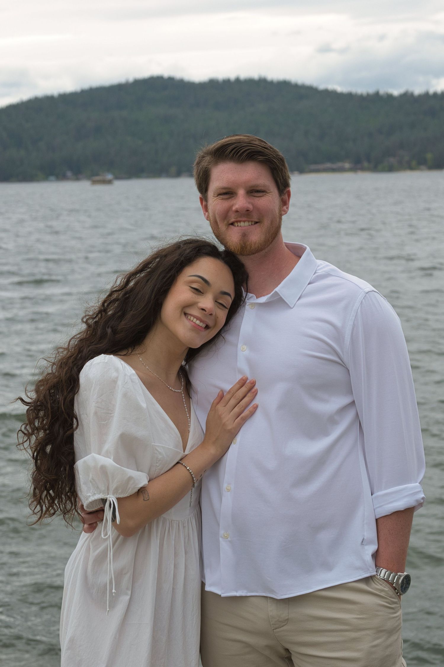 Woman leans her head against man's chest during engagement shoot