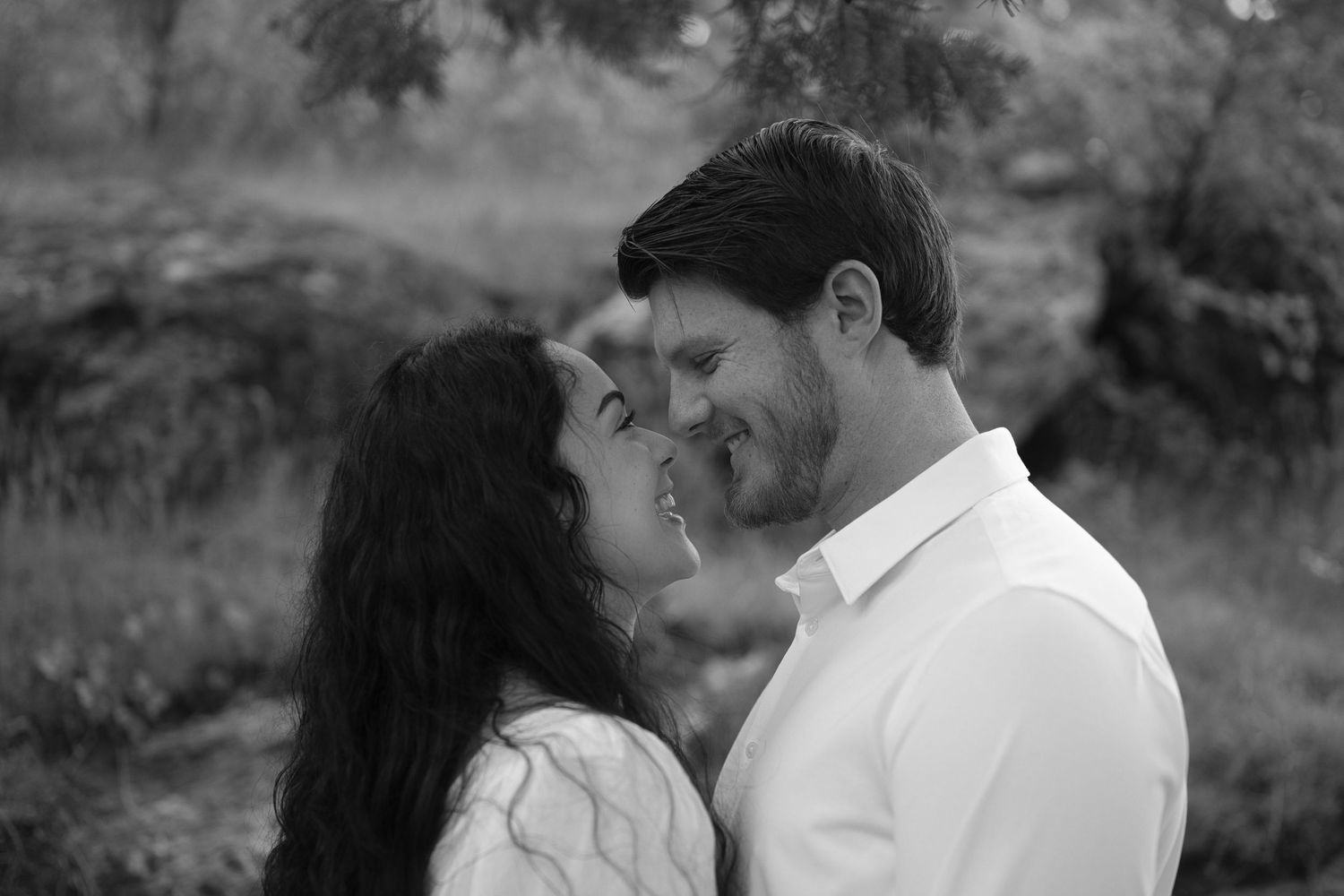 Couple look at each other with noses almost touching during engagement photos