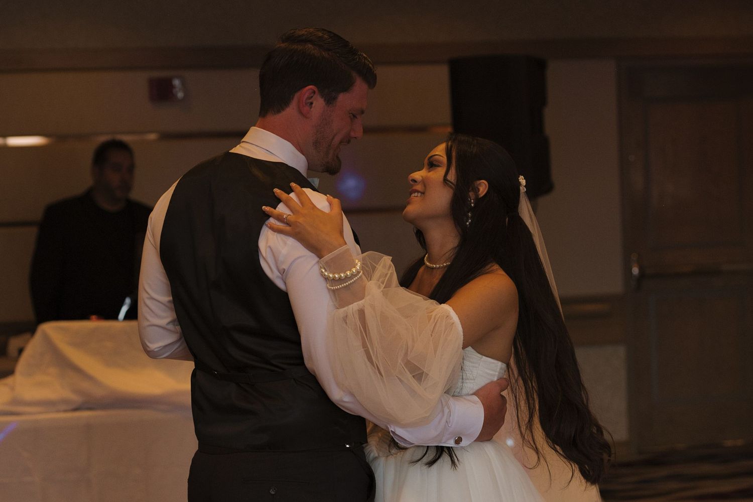 Bride and groom smiling at each other during first dance