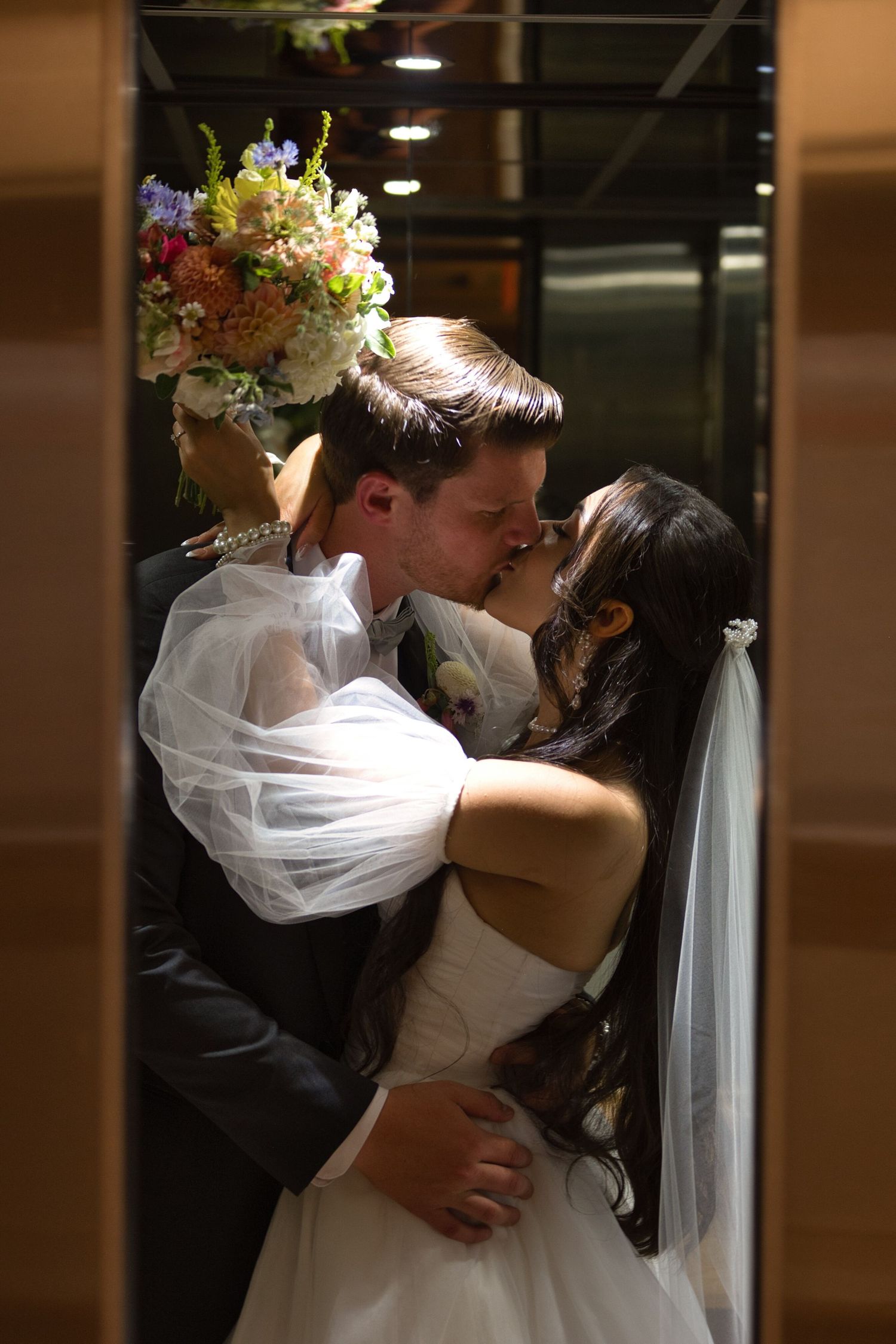 Bride and groom kiss in elevator in Coeur d' Alene Resort