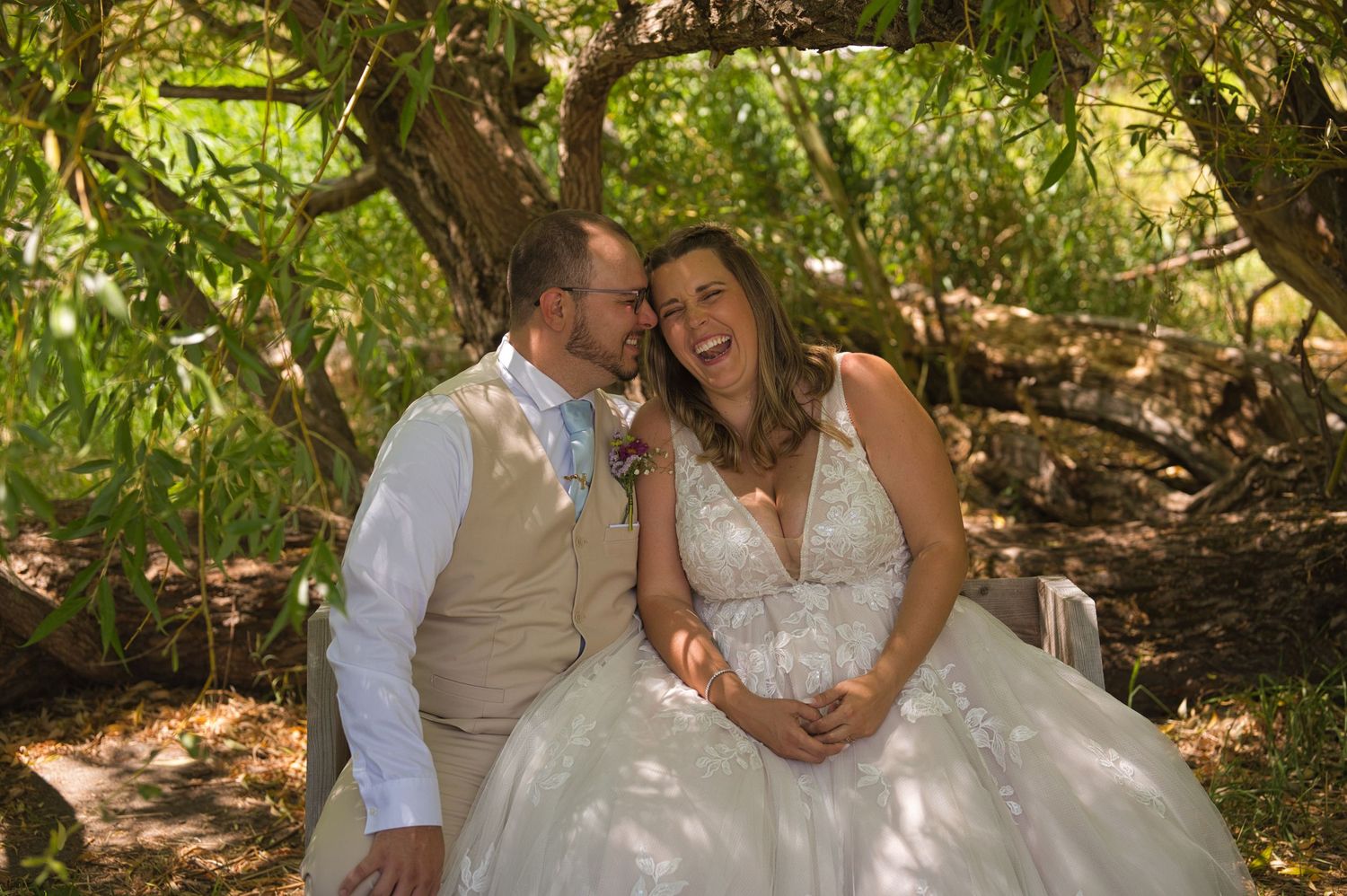 Bride laughs while groom smiles at her outside in North Idaho