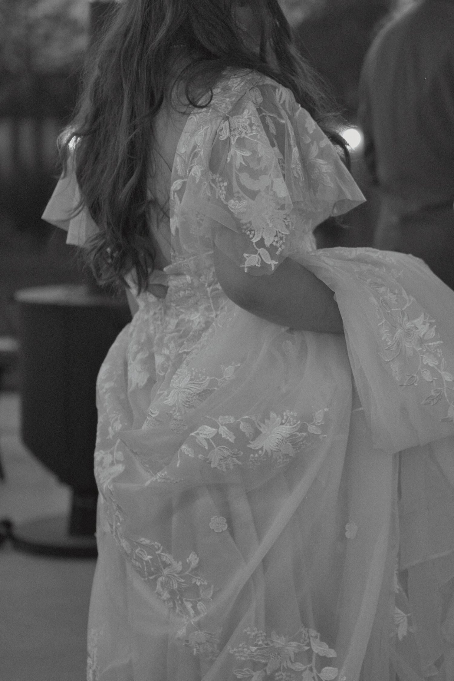 Candid moment of bride holding dress train
