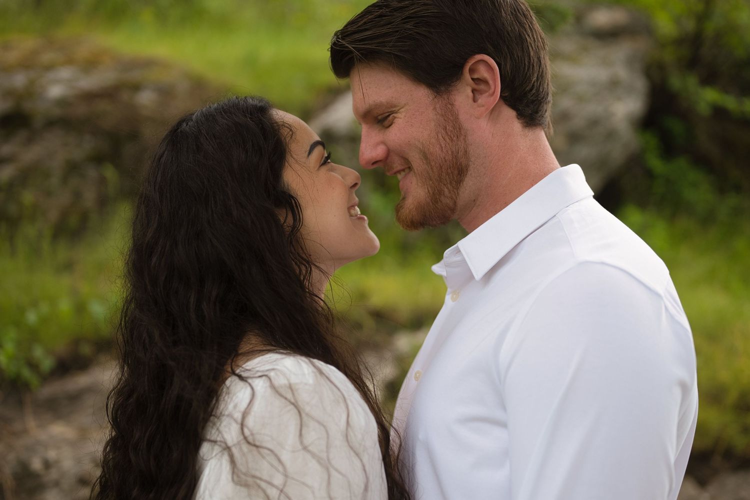 Couple smiling at each other during candid photos in North Idaho