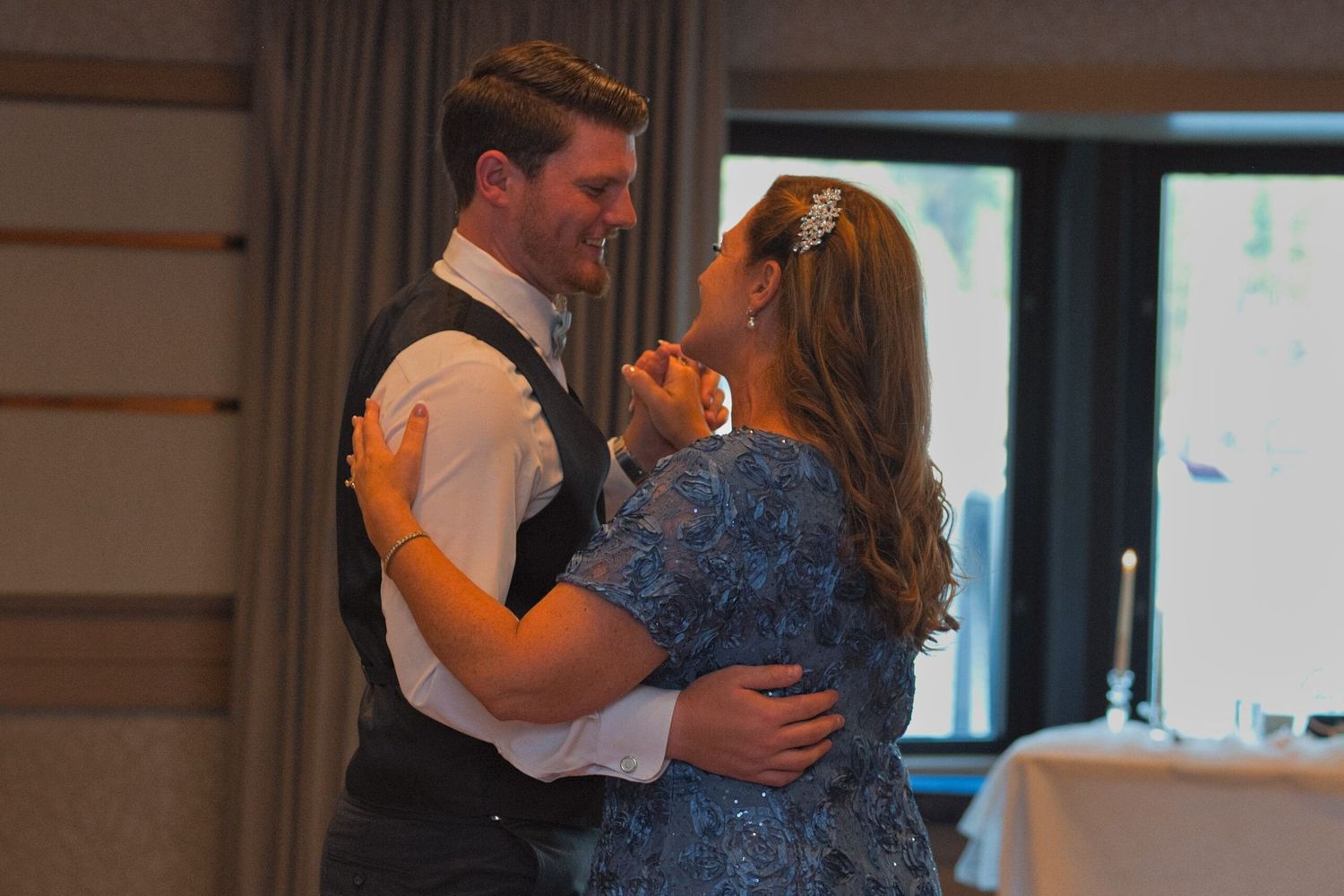 Groom smiles as he dances with his mom for the Mother-Son dance during the reception in a stateroom in the Coeur d'Alene Resort.