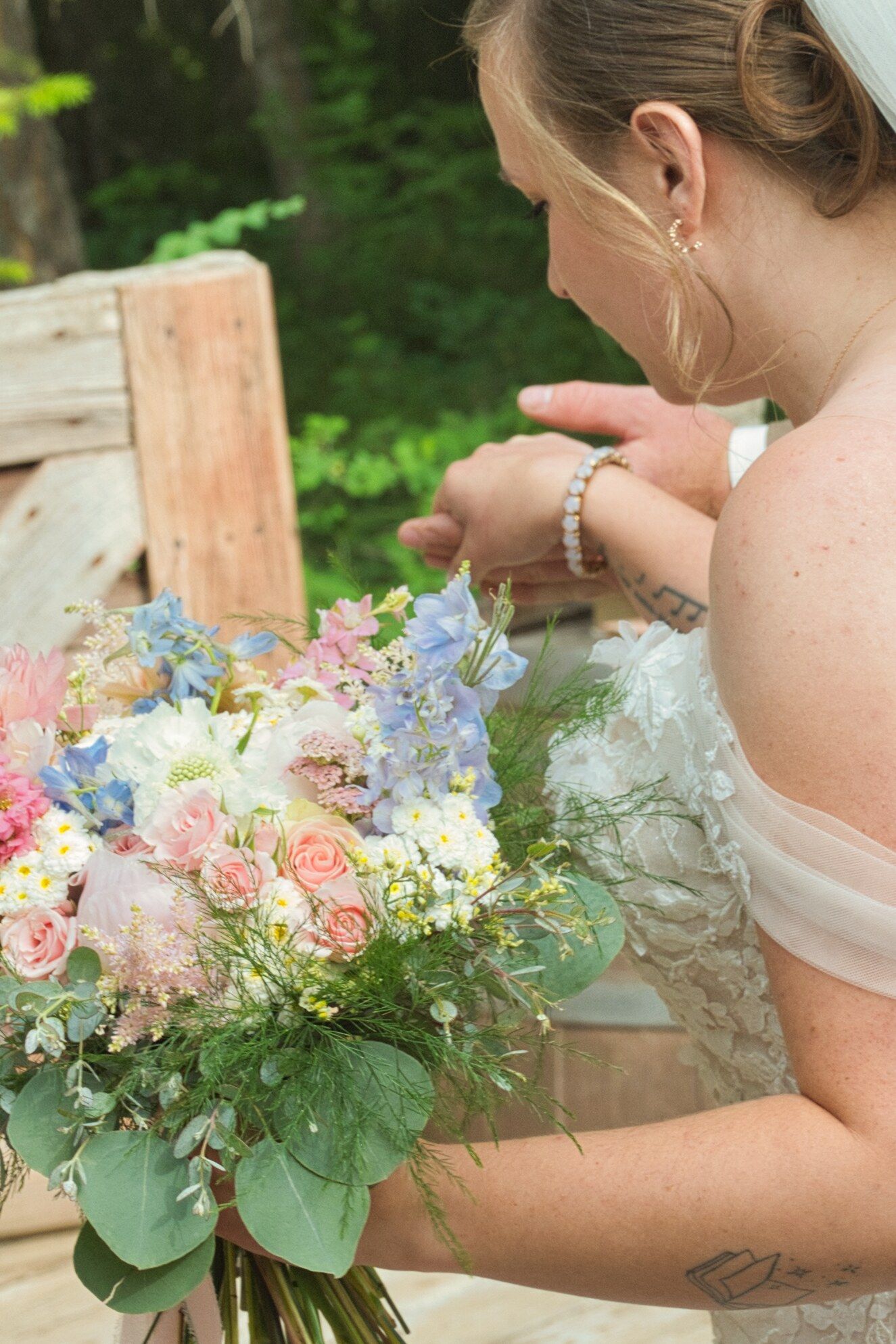 Groom leading Bride by her hand while the picture focuses on the bride's bouquet.