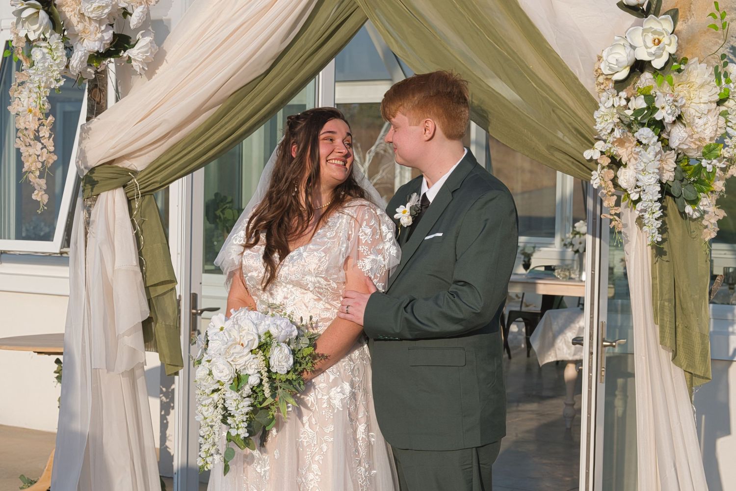 Bride looks at groom lovingly while standing for formal pictures