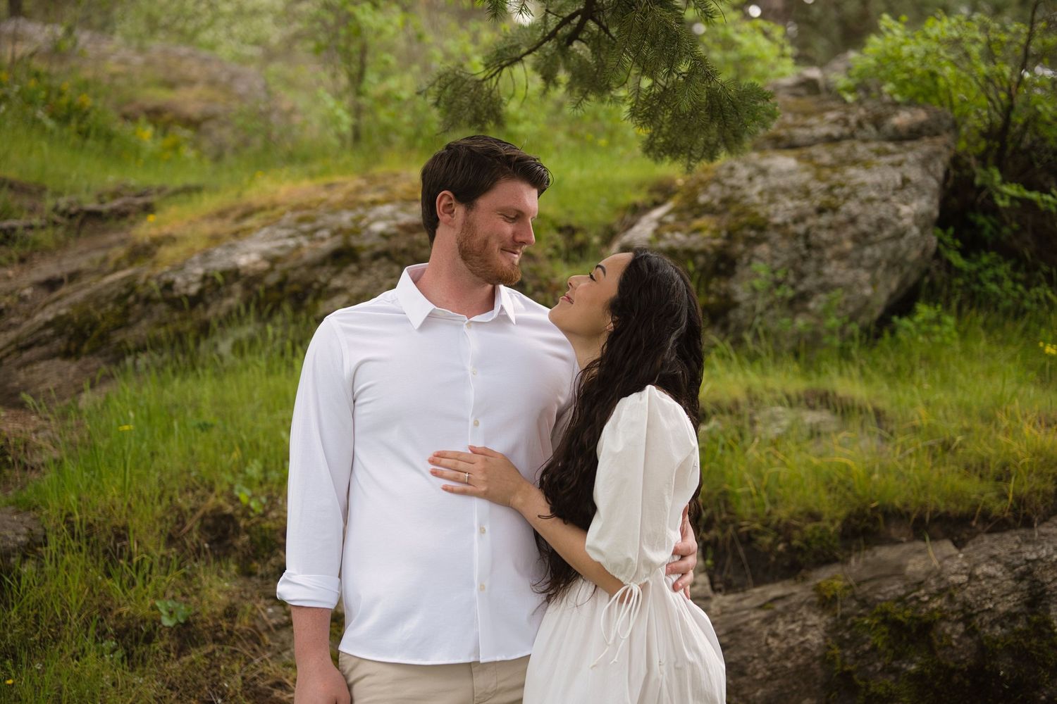 Couple look lovingly at each other in the woods in North Idaho