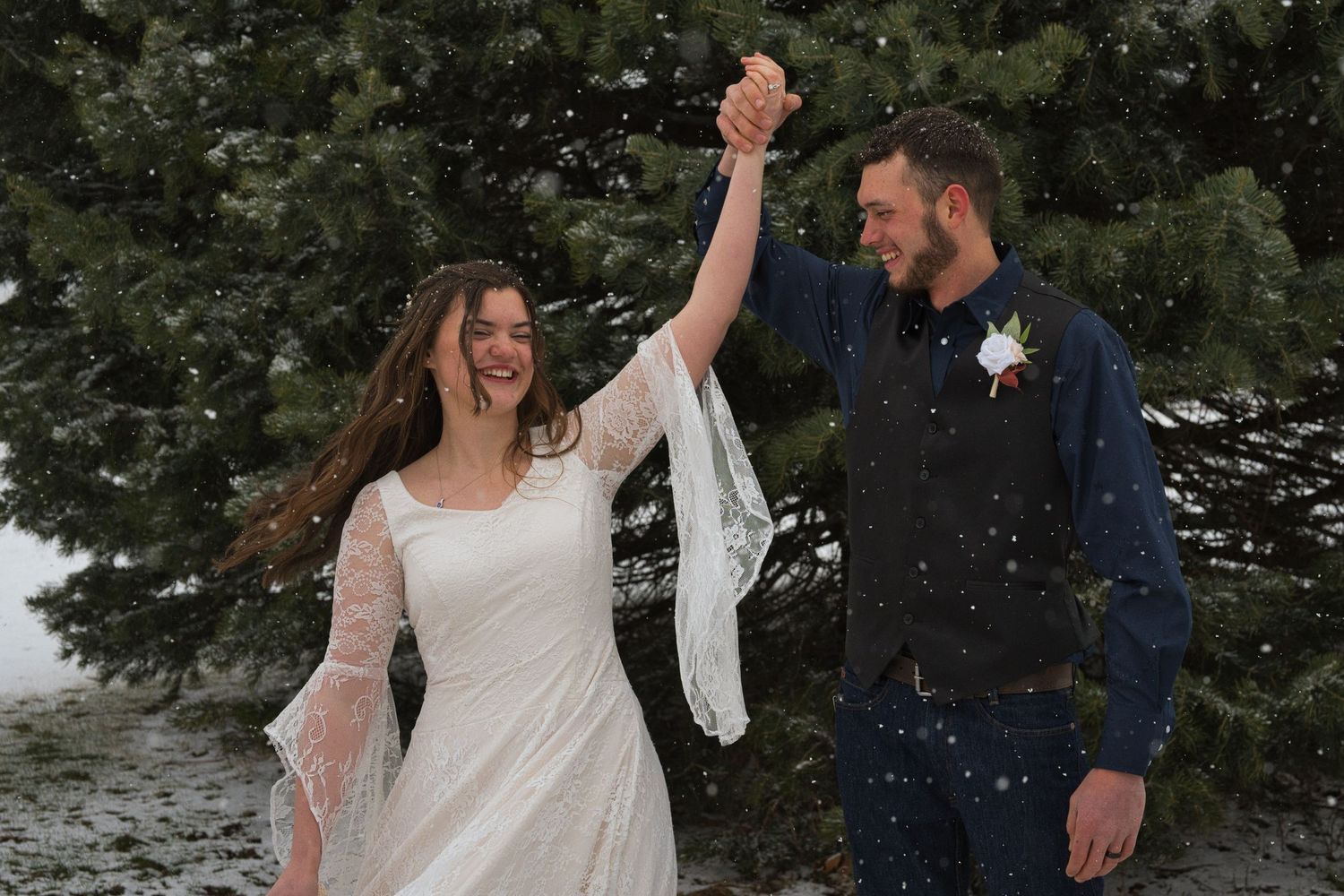 Couple spinning in the snow before their ceremony in Sandpoint, Idaho