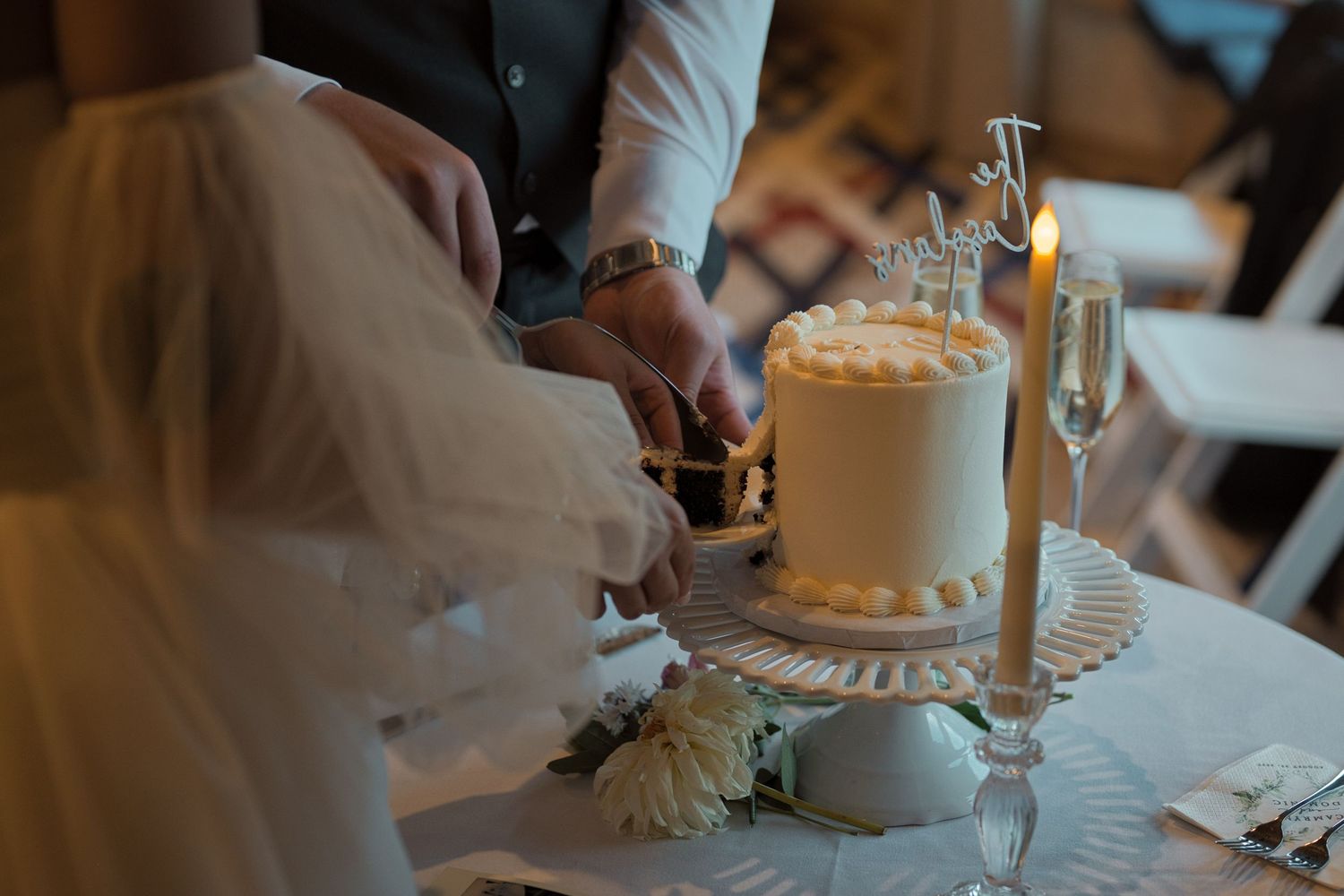 Groom and bride cut cake together during reception