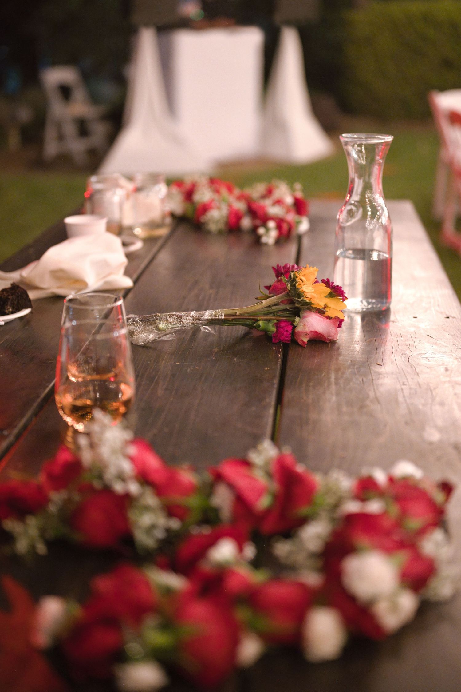 Candid photo of the head table after reception with the brides bouquet and the couple's flower garland necklaces.