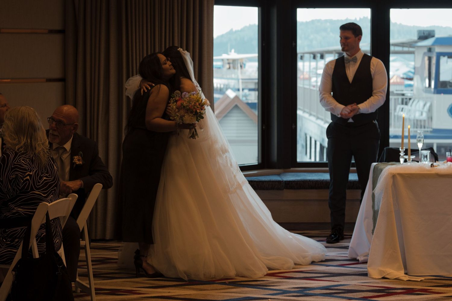 Bride hugs her mother as she dedicates her flower bouquet to her mother during wedding speeches.