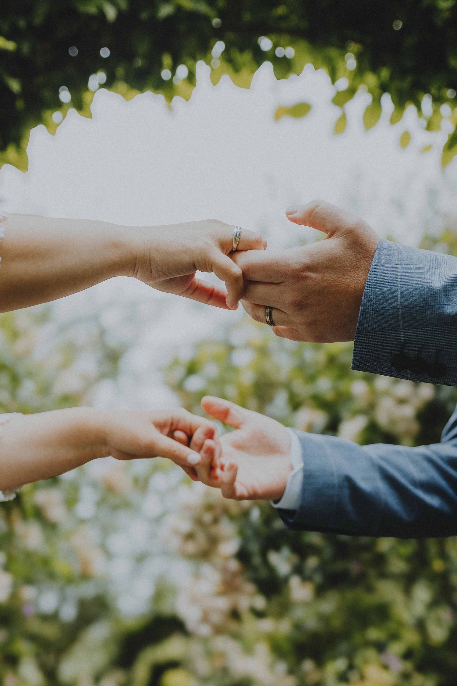 Een gelukkig stel houdt elkaars handen vast op hun trouwdag in de rozentuin van Kortrijk