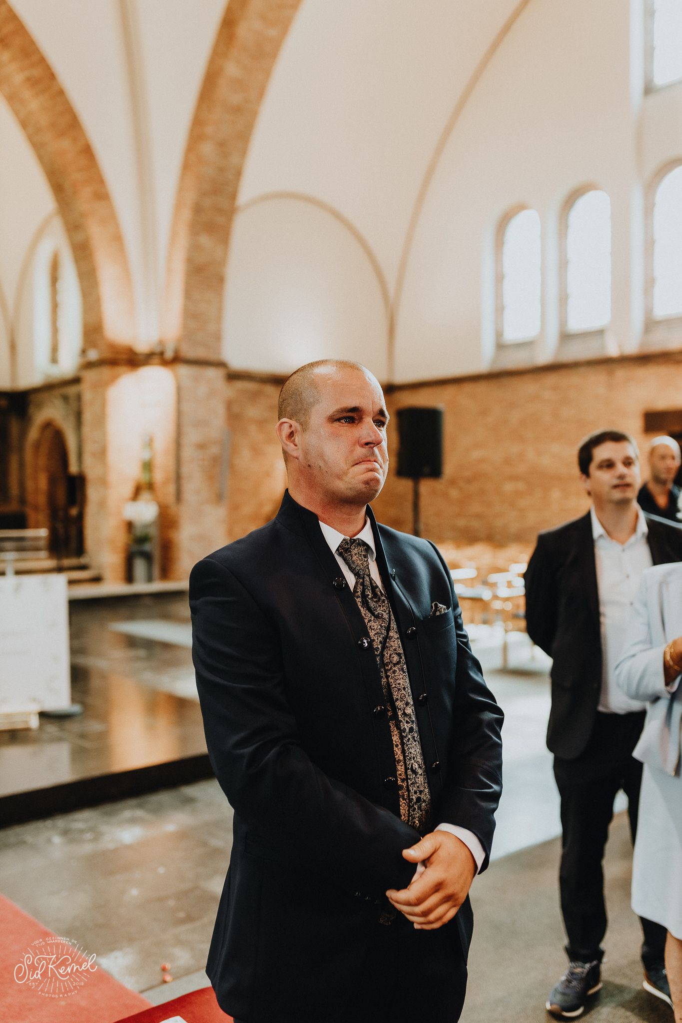 emotionele bruidegom die wacht op zijn toekomstige vrouw in een kerkje gelegen in Oostende.