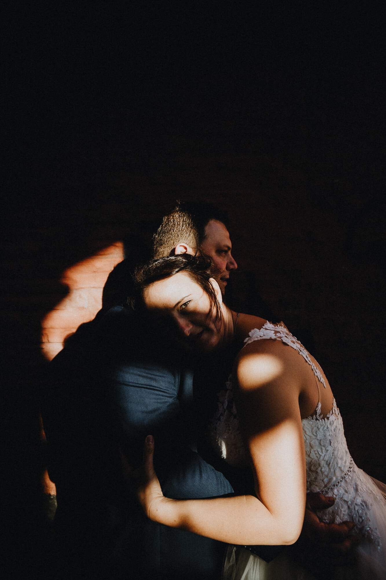 Een bruid en bruidegom omhelzen elkaar in de duisternis, stralend van liefde en verbondenheid in het hartje van Sint Andries Brugge