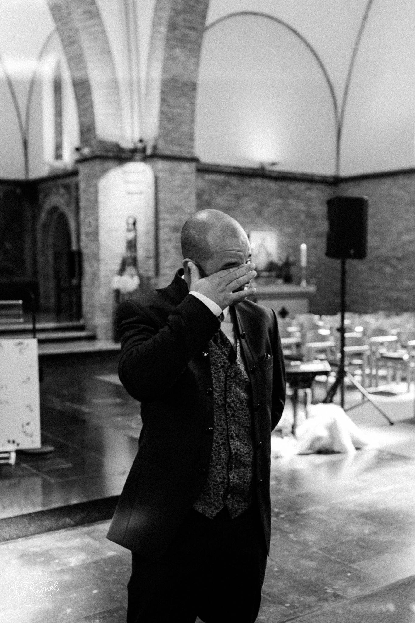emotionele bruidegom die zijn traan weg veegt na het zien van zijn toekomstige vrouw in een kerkje gelegen in Oostende.