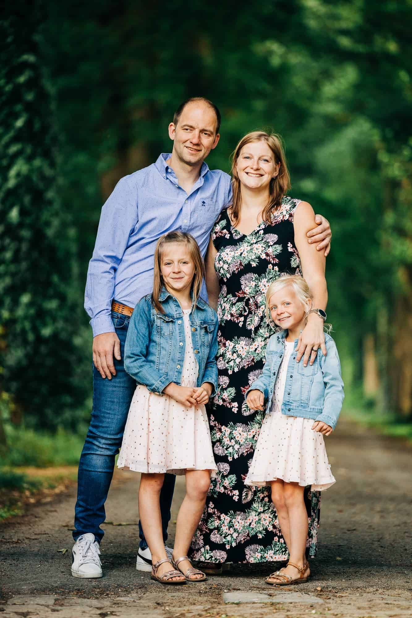 spontane gezin foto in op een keien weg tussen groene bomen tijdens de middag