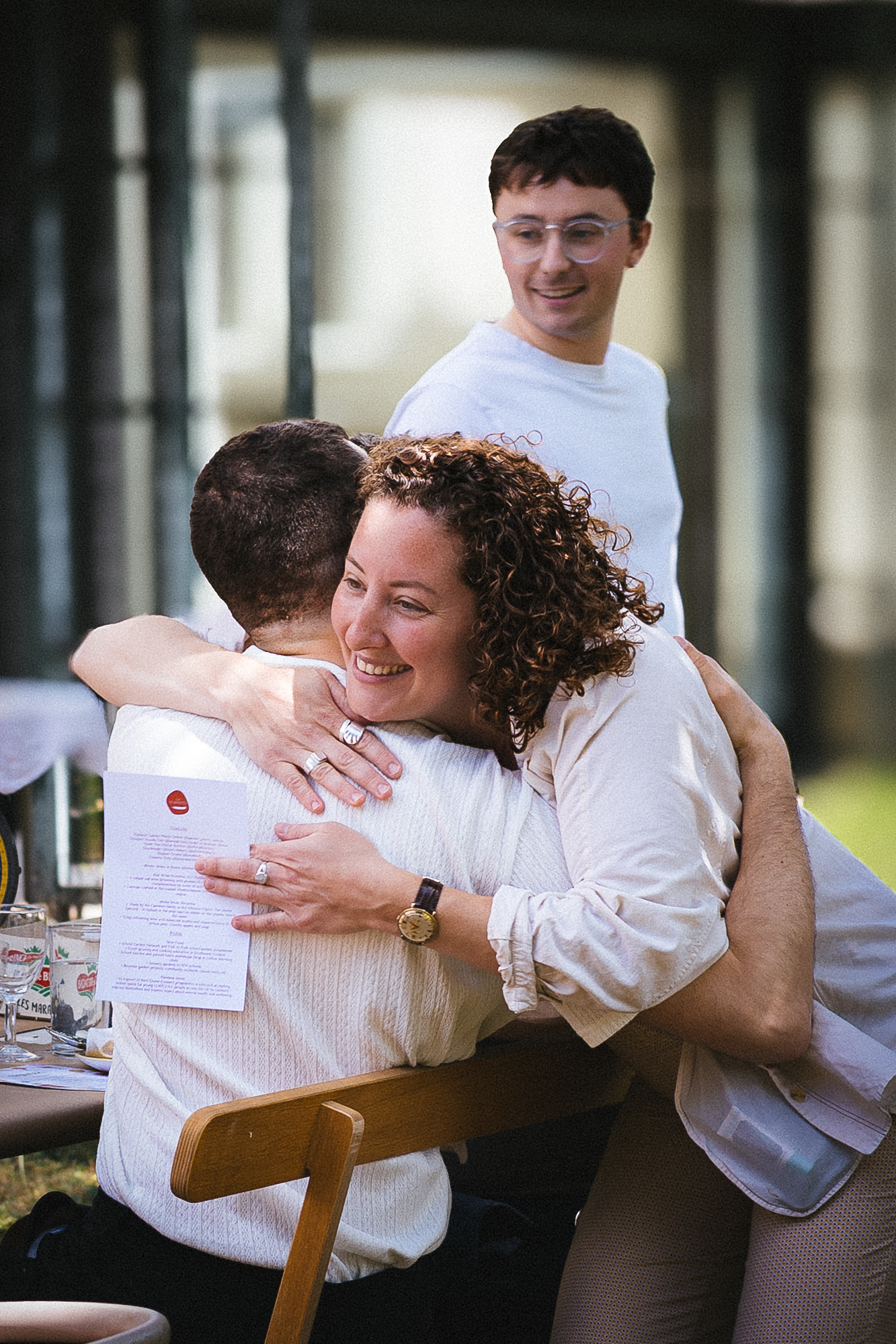 Friends share warm embraces during a celebratory moment.