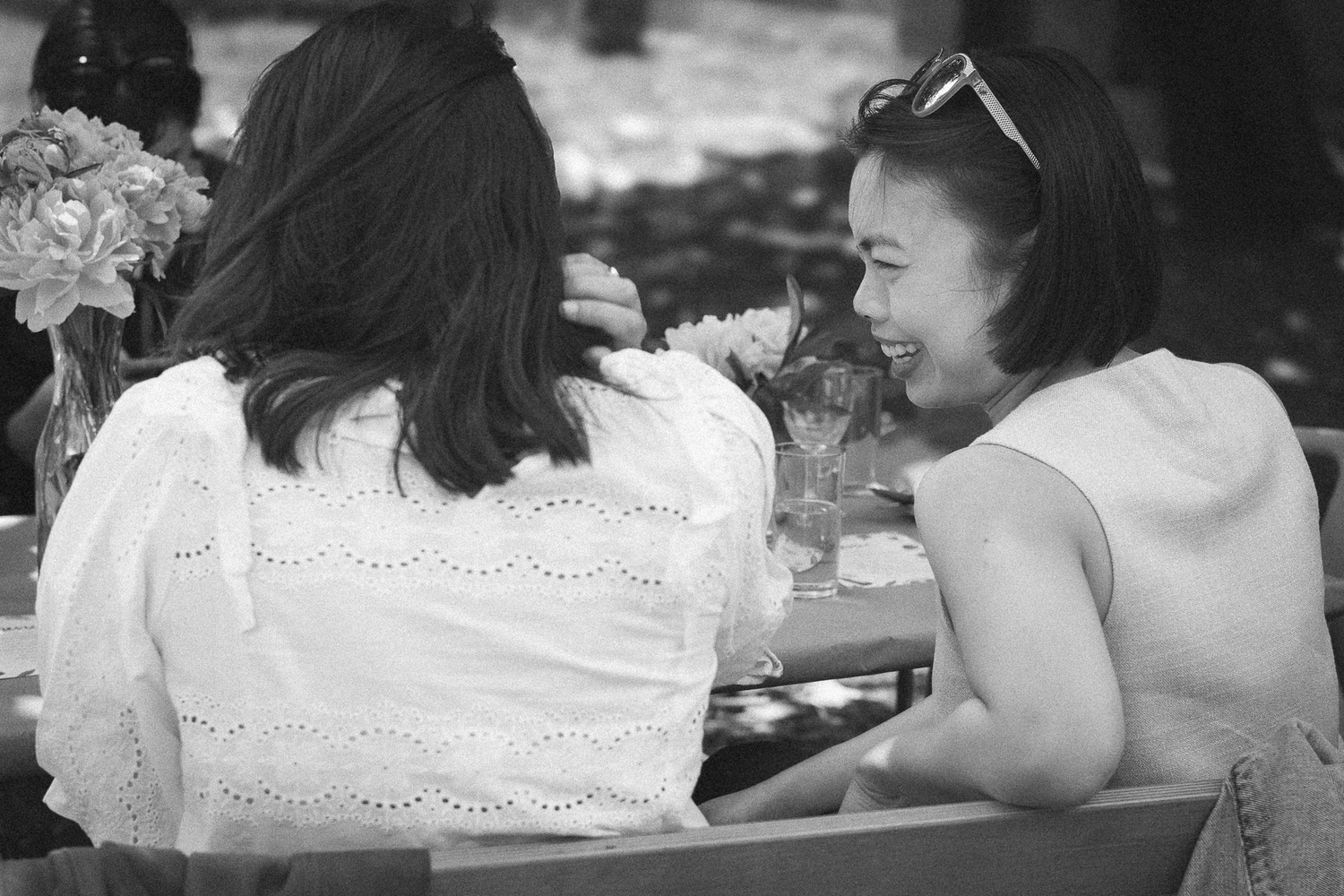 A black and white photo captures guests seated at an outdoor celebration.