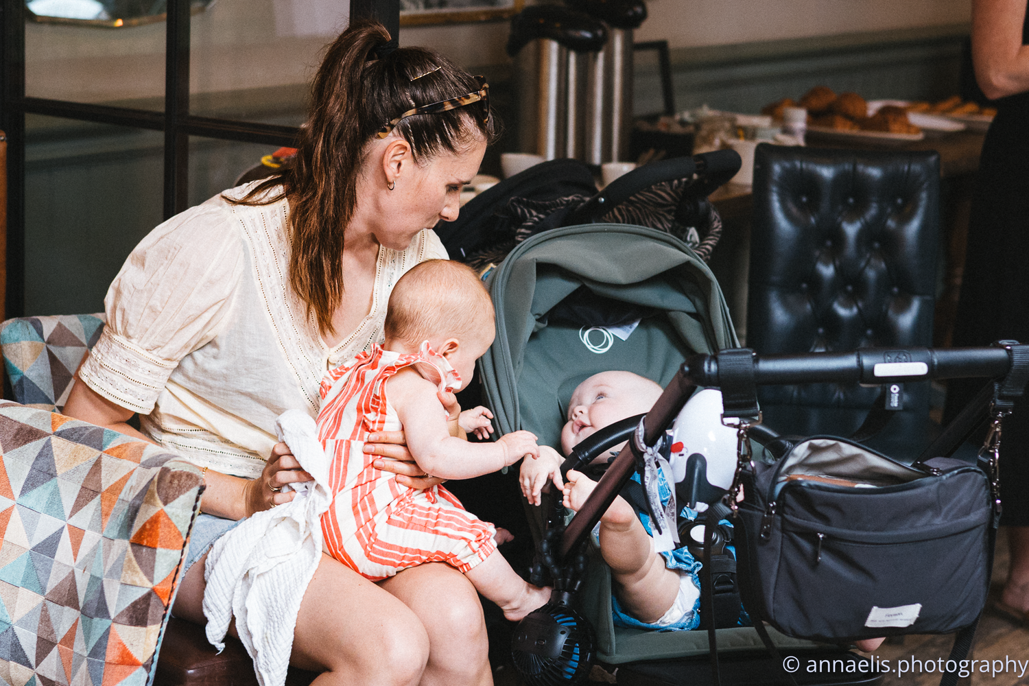 Parents and babies gather in a casual indoor setting for a social meetup.