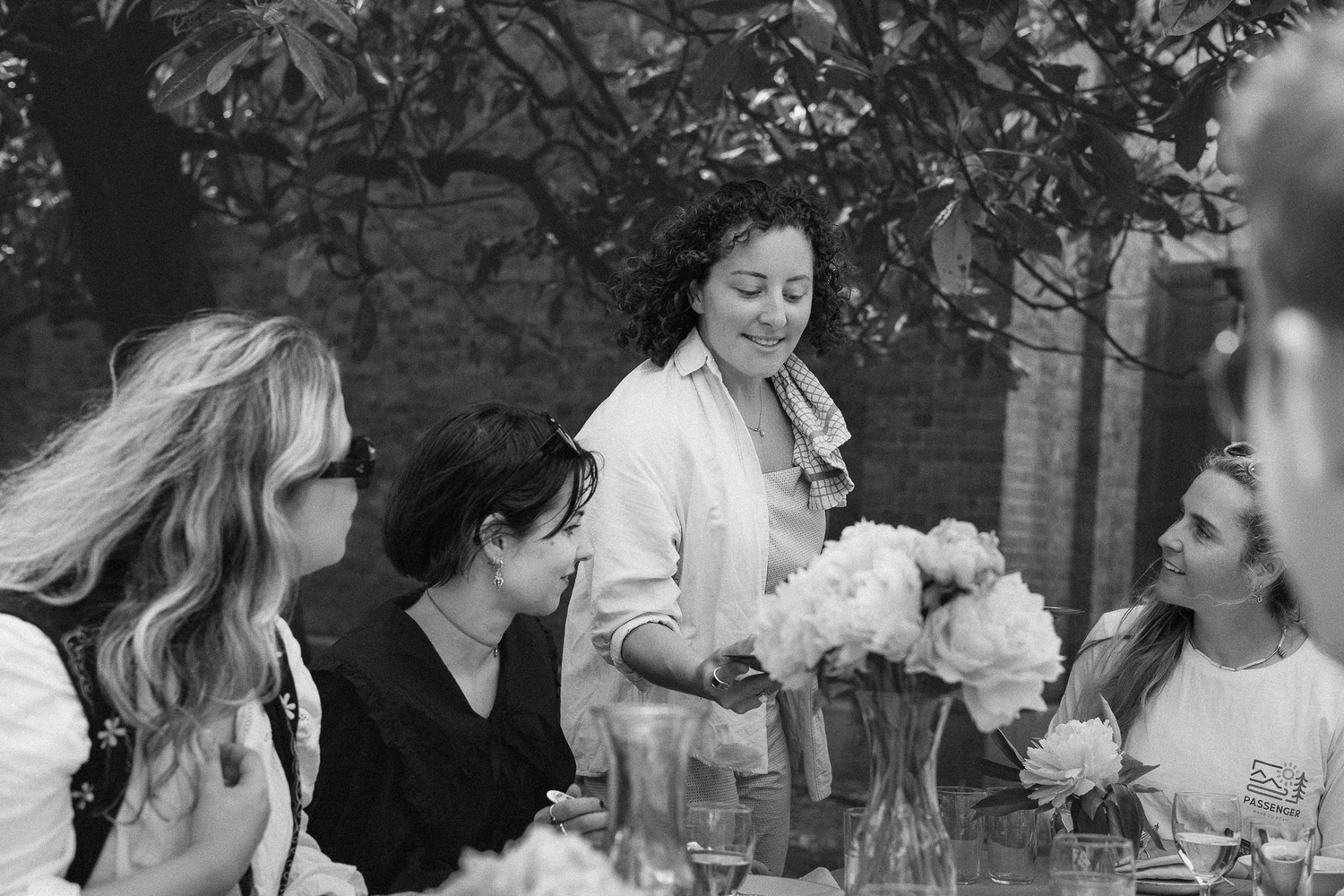 People enjoying an outdoor gathering with drinks and conversation.