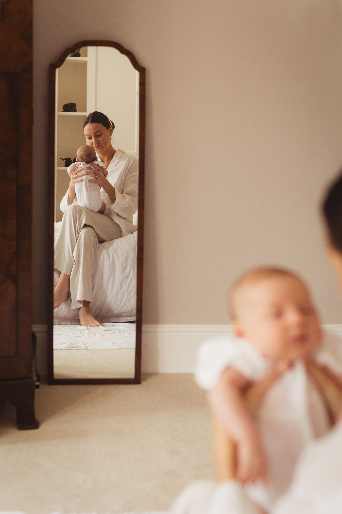 Series of reflections in a wall mirror showing tender moments with a baby.