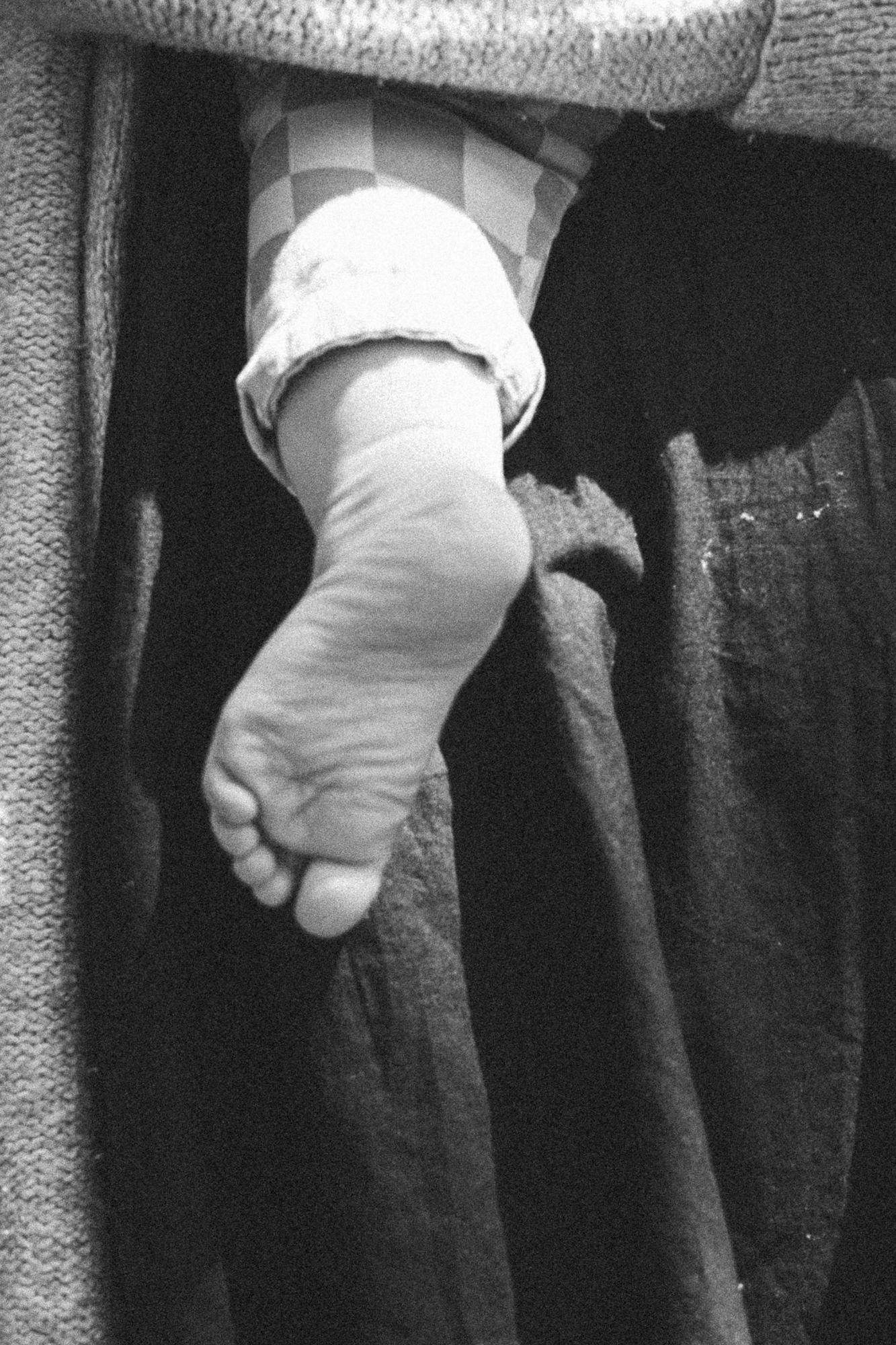 Black and white close-up of tiny baby feet in a row.