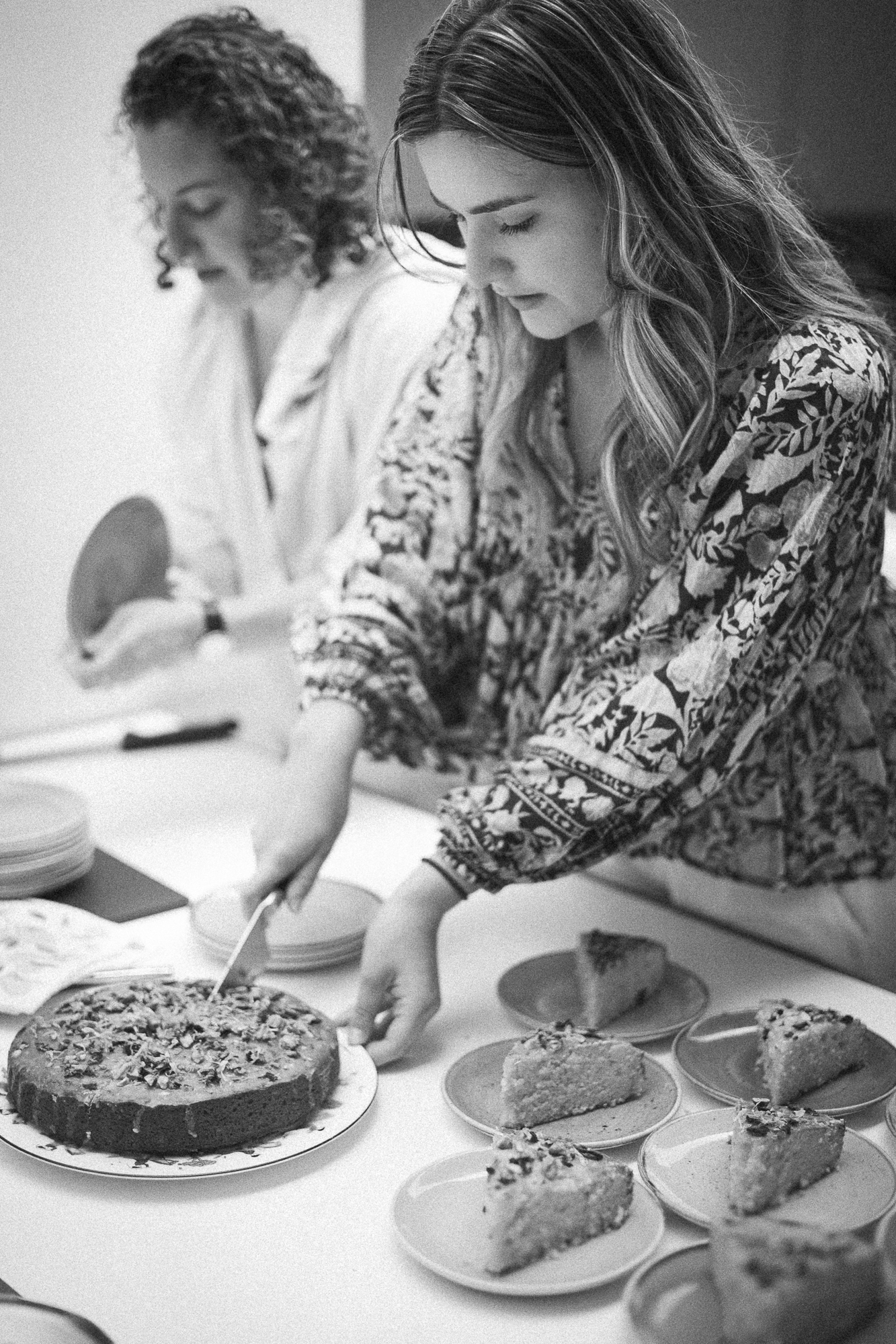 People examining and tasting slices of cake at a dessert tasting event.