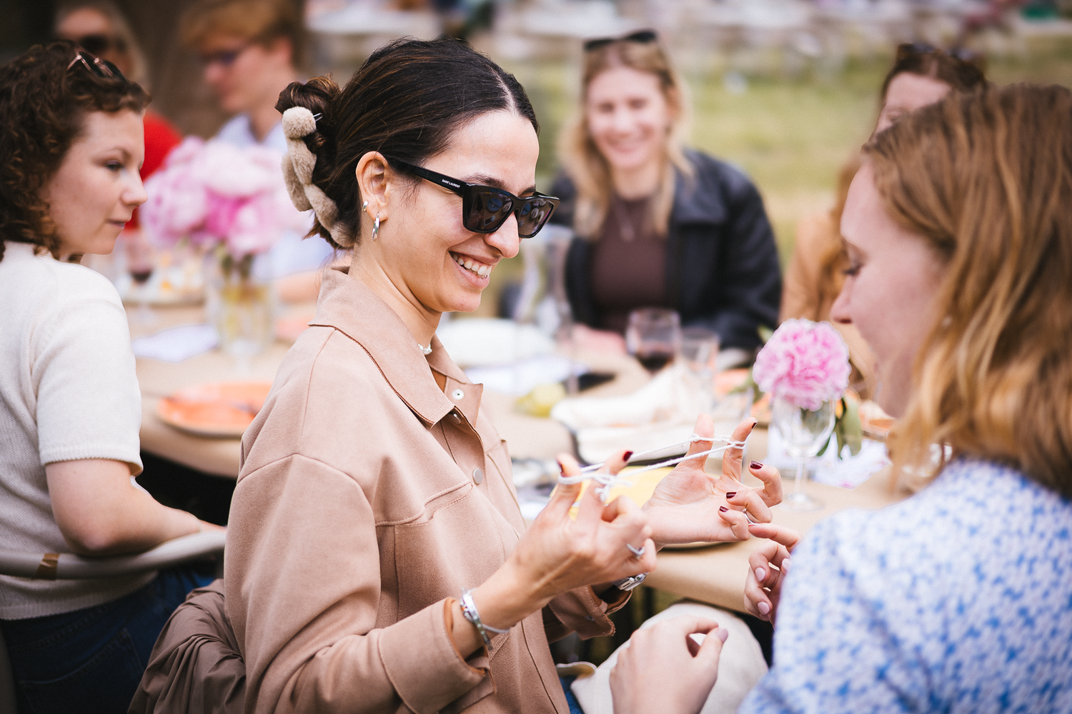 Casual outdoor dining scene with guests enjoying conversation at a garden party.