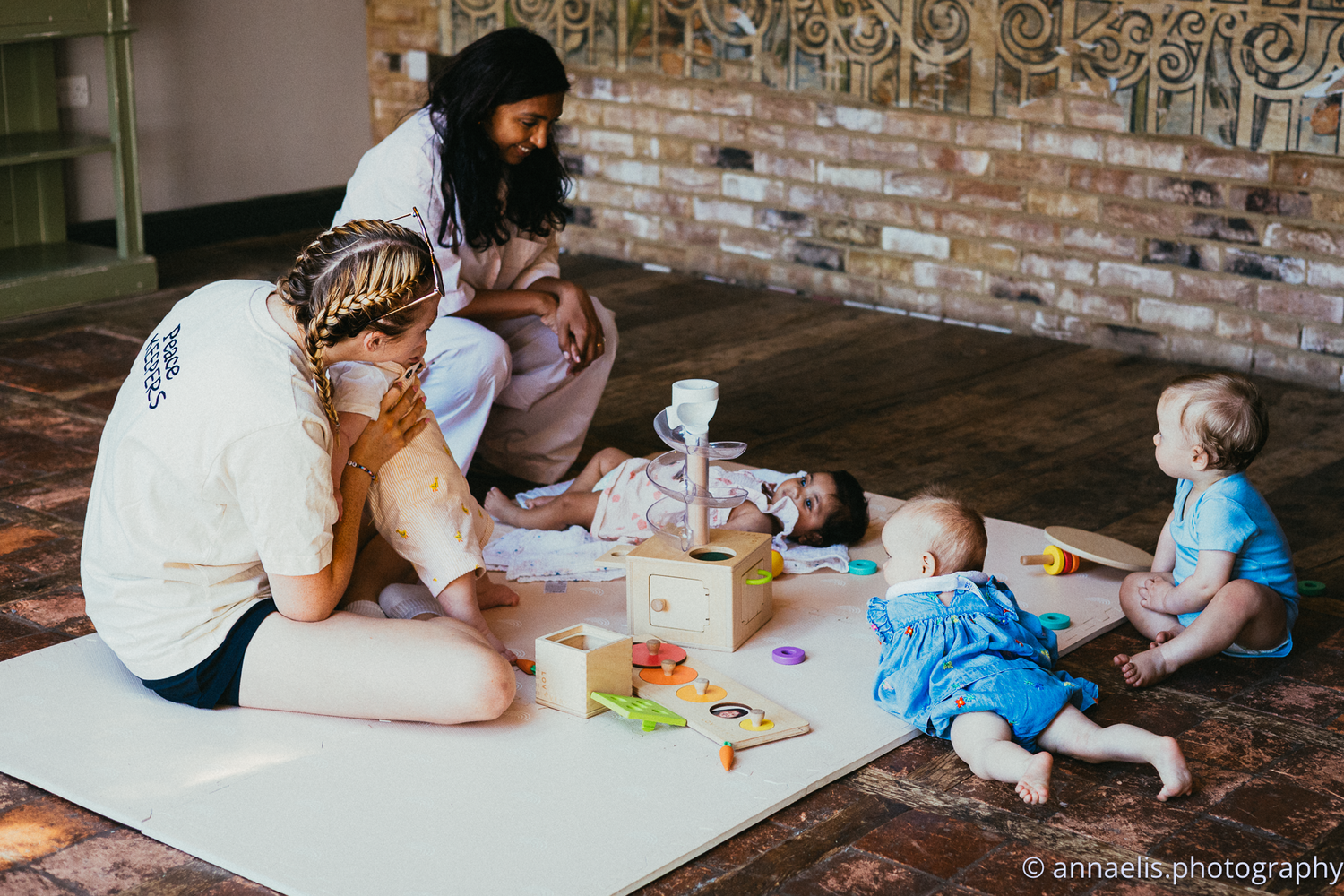 Parent and child lying on floor coloring together with art supplies and toys.