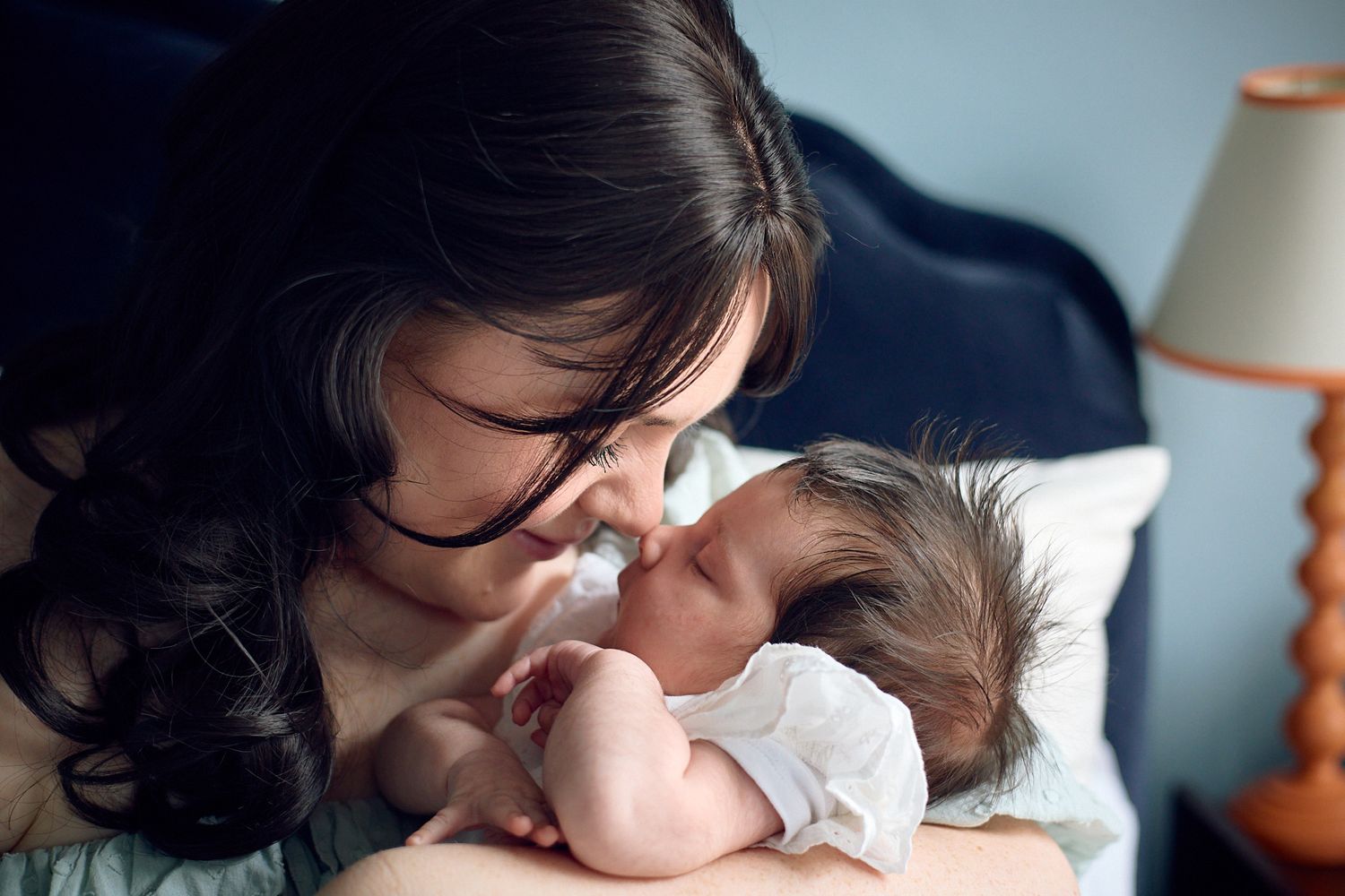 A tender nurturing moment captured in intimate lighting.