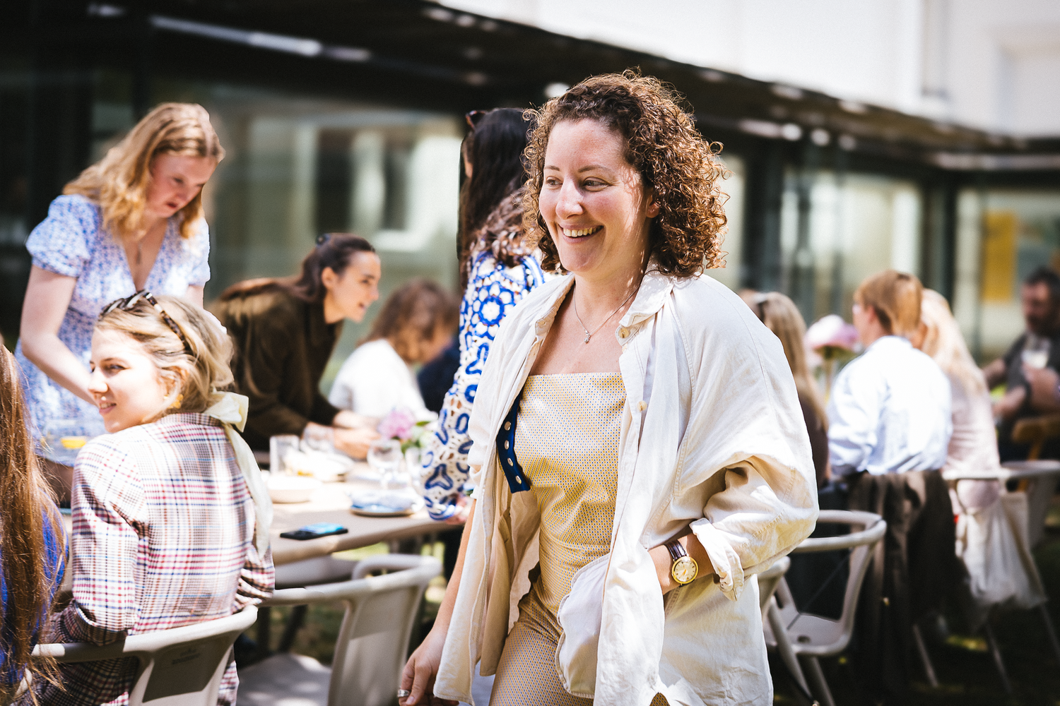 People socialize at an outdoor celebration with natural lighting.