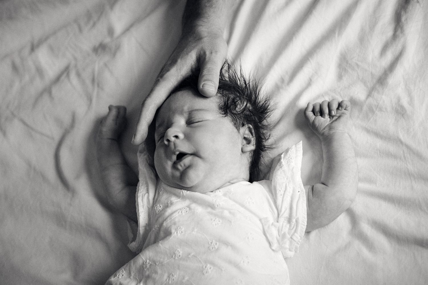 Black and white images of peaceful sleeping moments on white bedding.