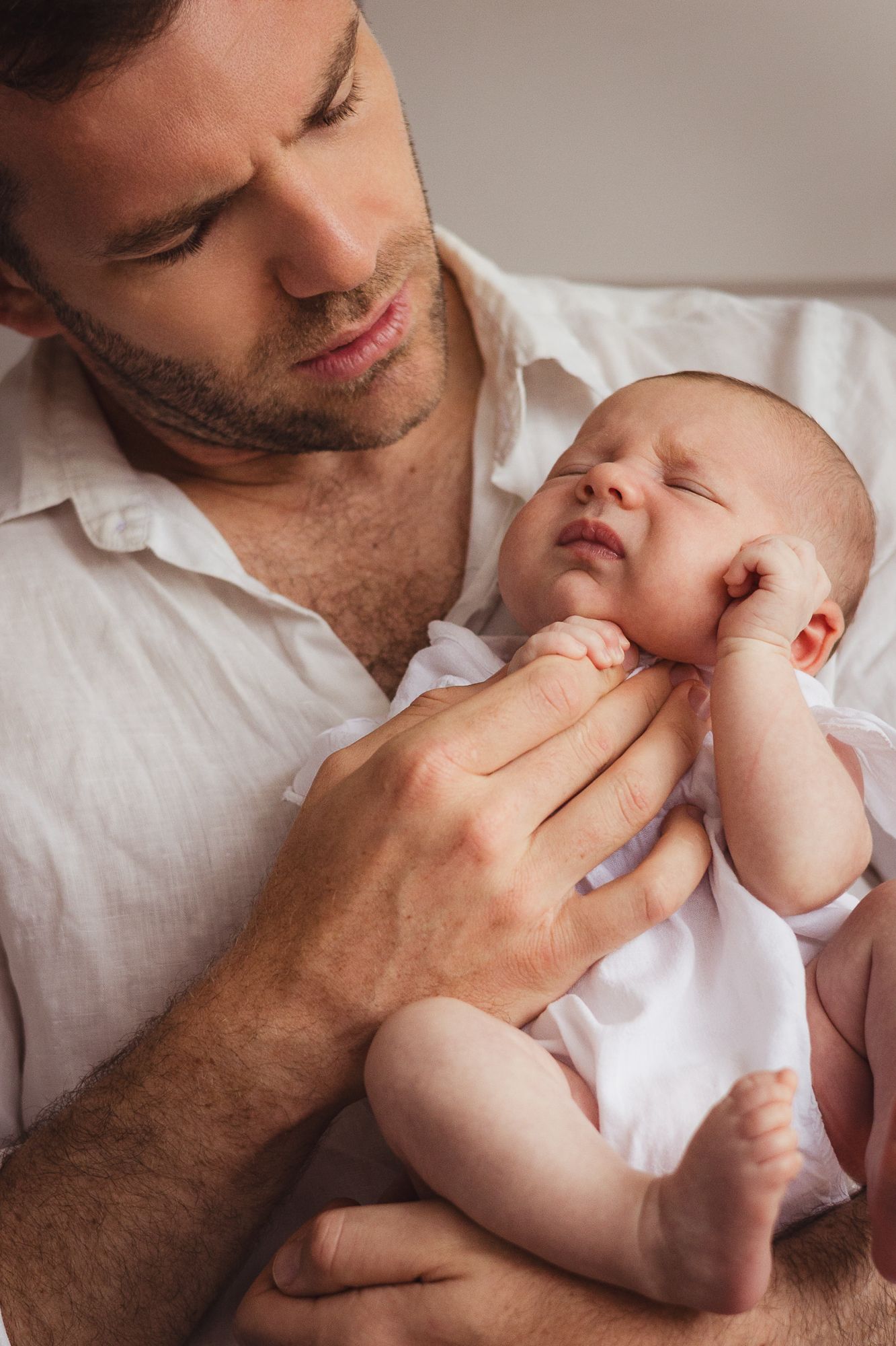 Close-up series of tender moments between parent and baby in soft lighting.