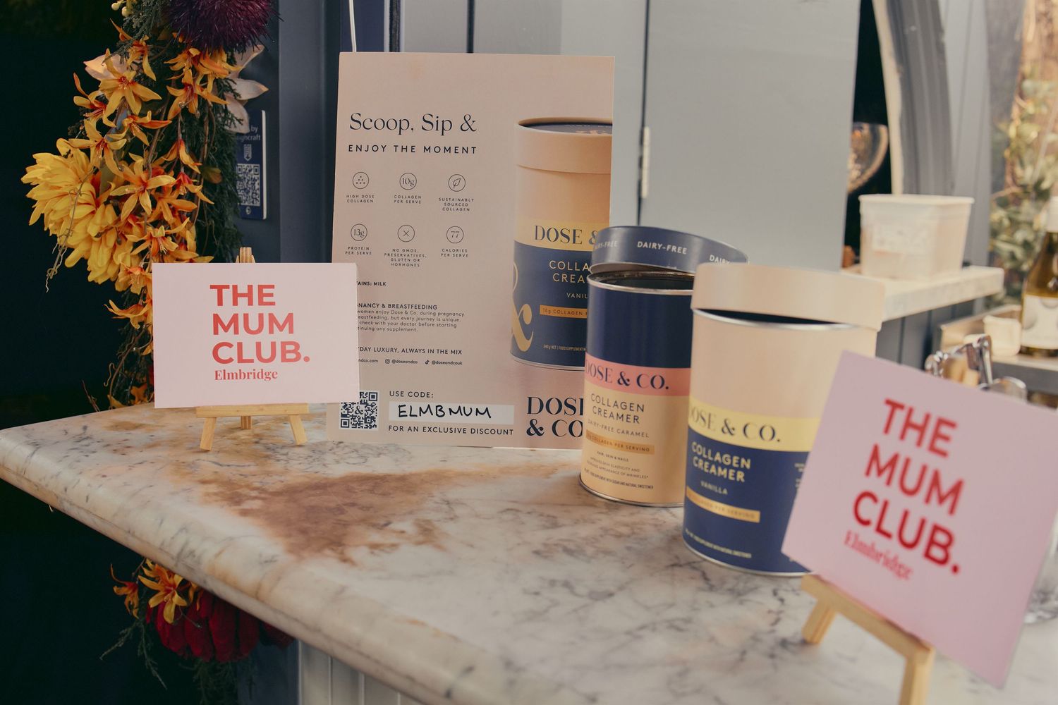 The Mum Club event display with Dose and Co collagen products on a marble table.