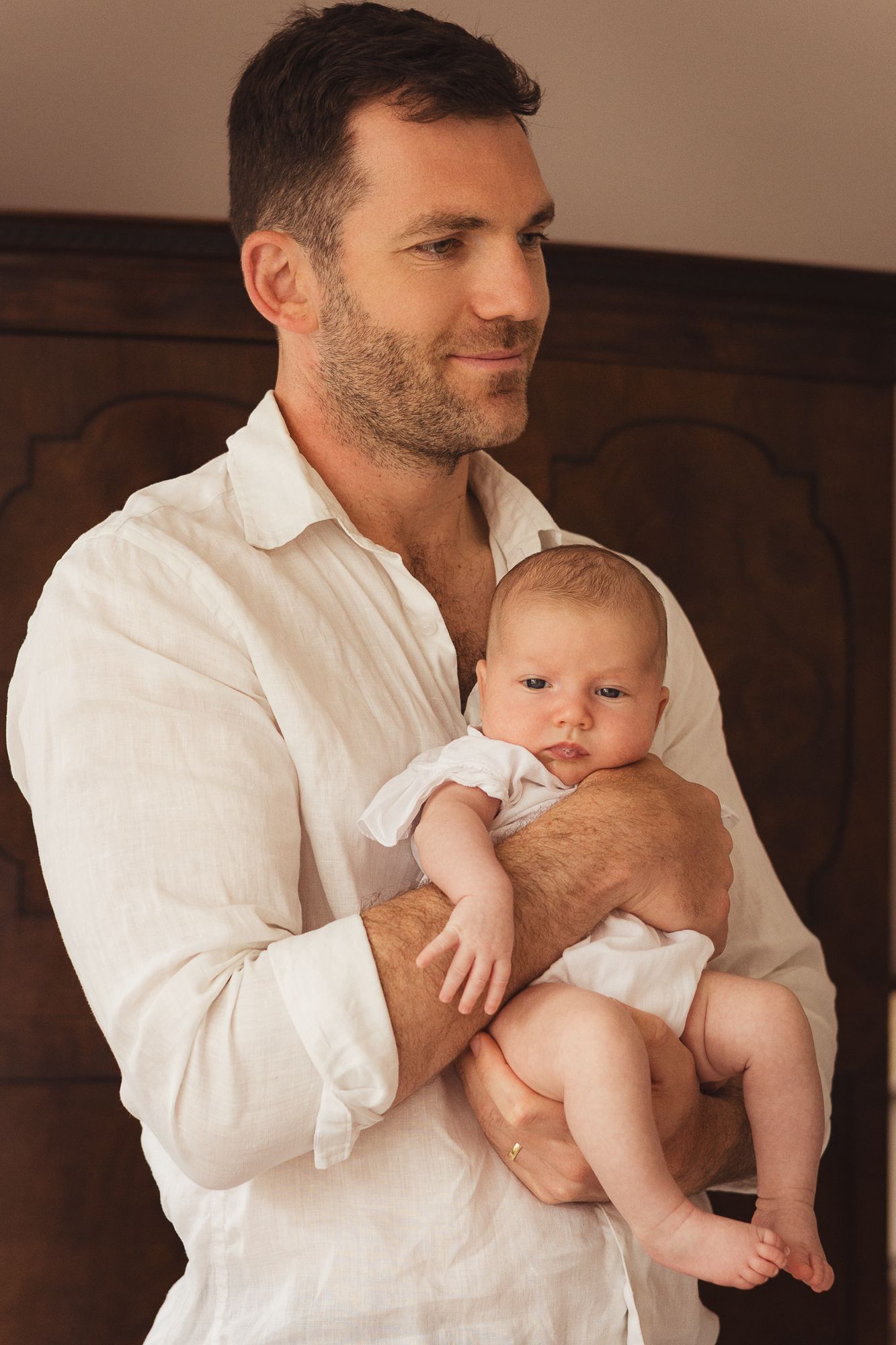 Parent in white shirt holding and bonding with small infant.