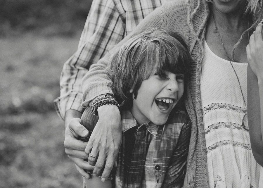 Black and white candid photo capturing joy and laughter during a family moment.